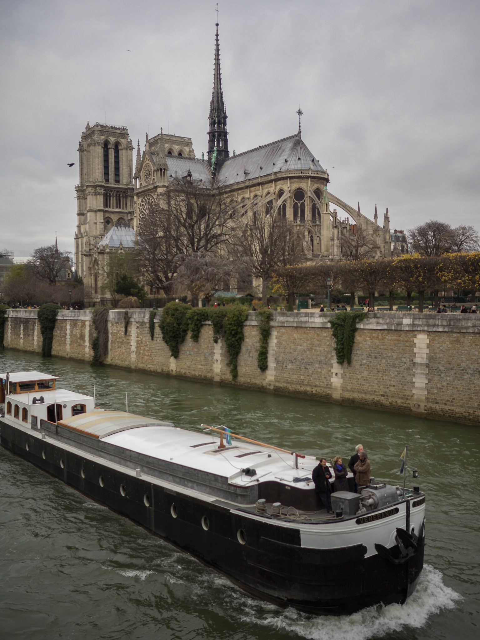 Barge in Seine river by Notre Dame de Paris cathedral