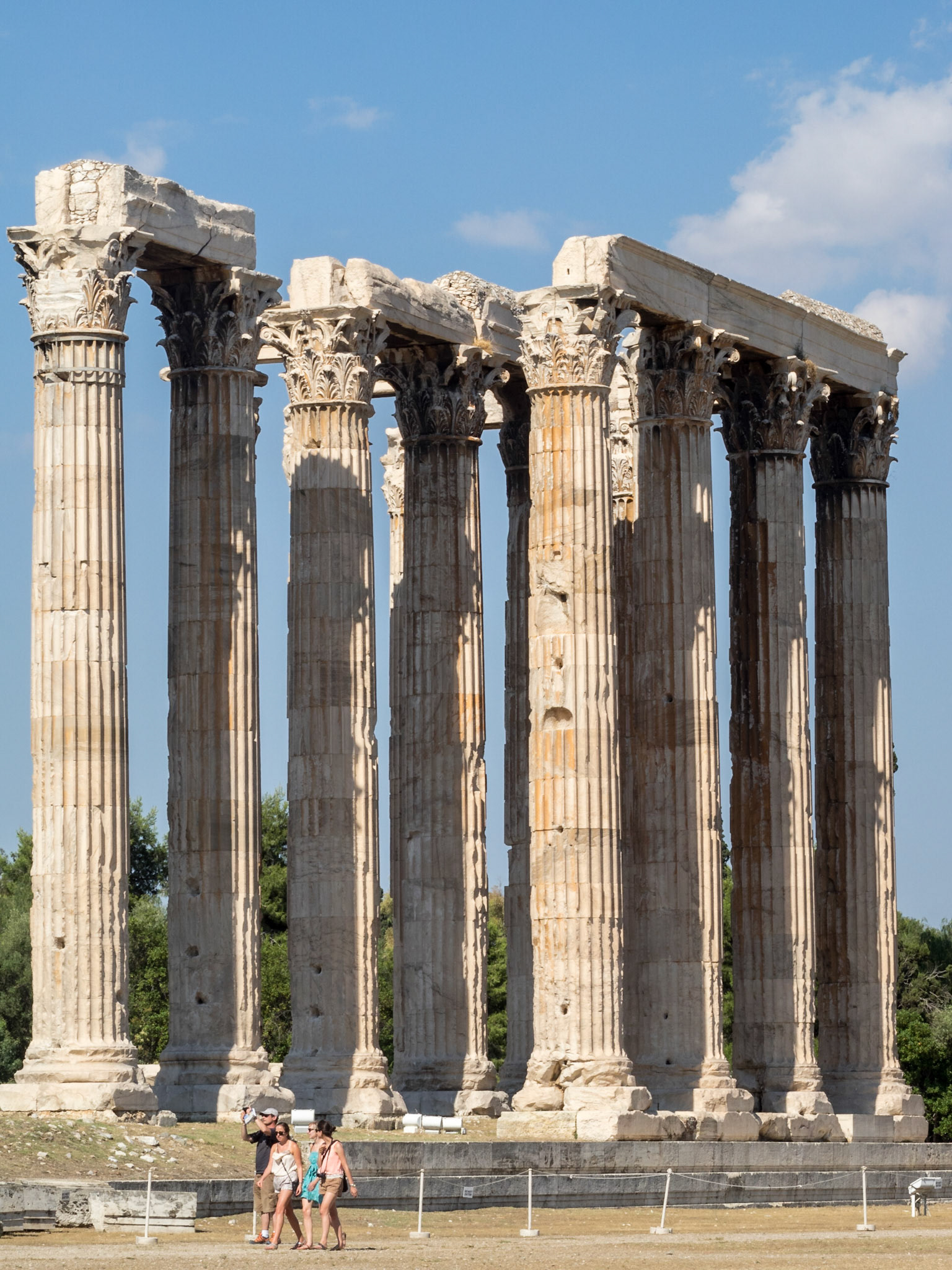 Tourists passing by the Olympian Zeus temple ruins in Athens