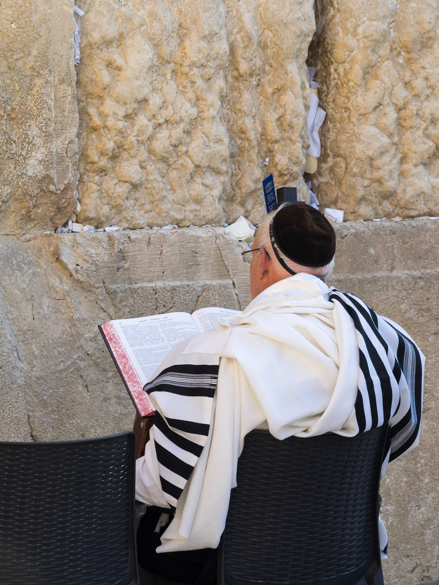 Old Jewish man in traditional costume reading the Torah by the Western Wall
