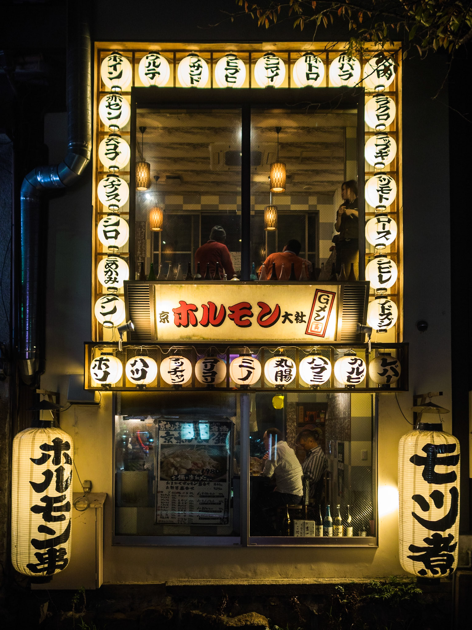 People seen  through the windows inside a Kyoto restaurant