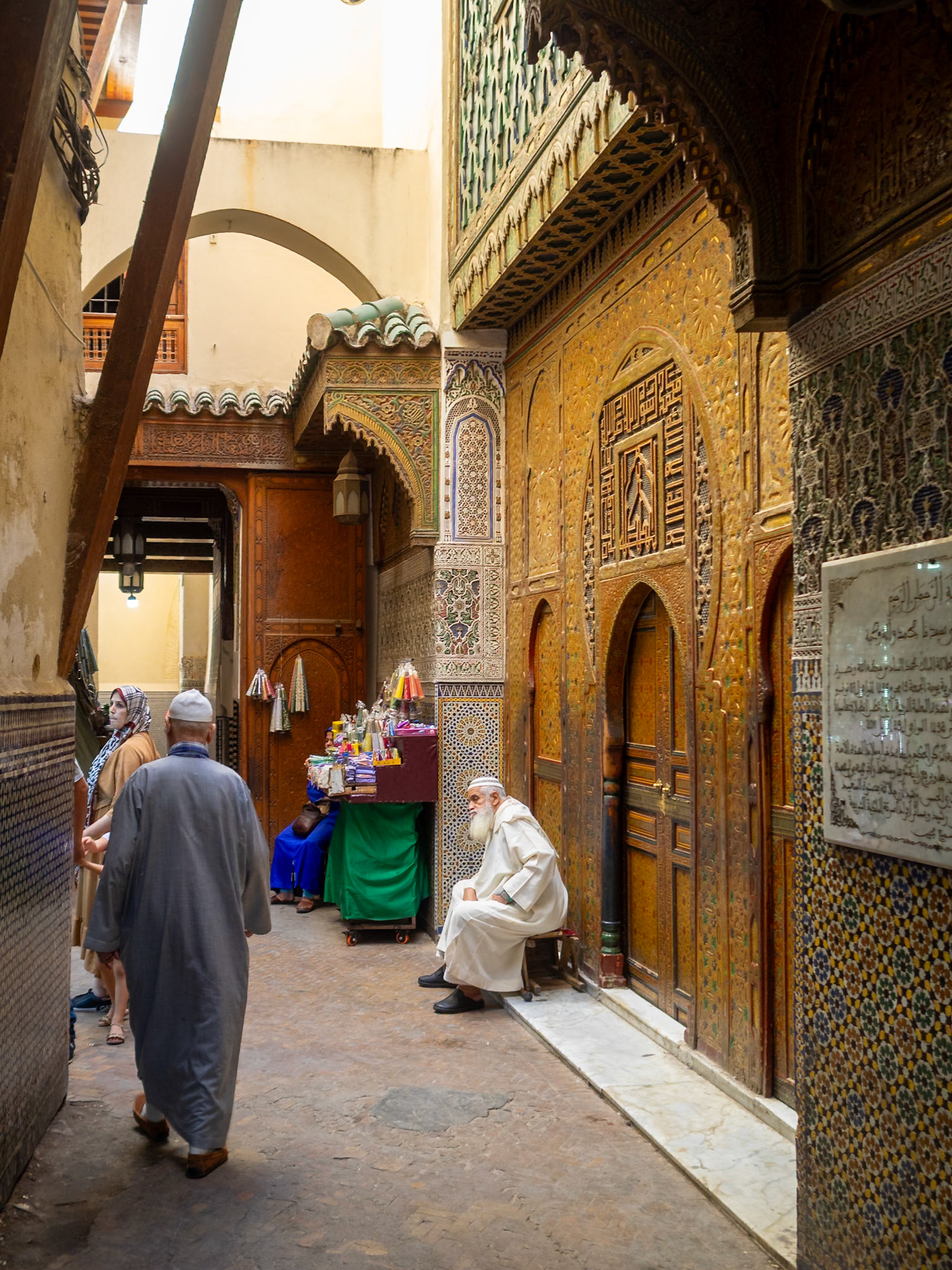 A muslim man seated at the doorrway of the