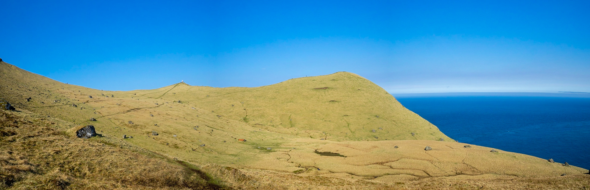 Kallur lighthouse hiking path between the yellow grass landscape of Kalsoy