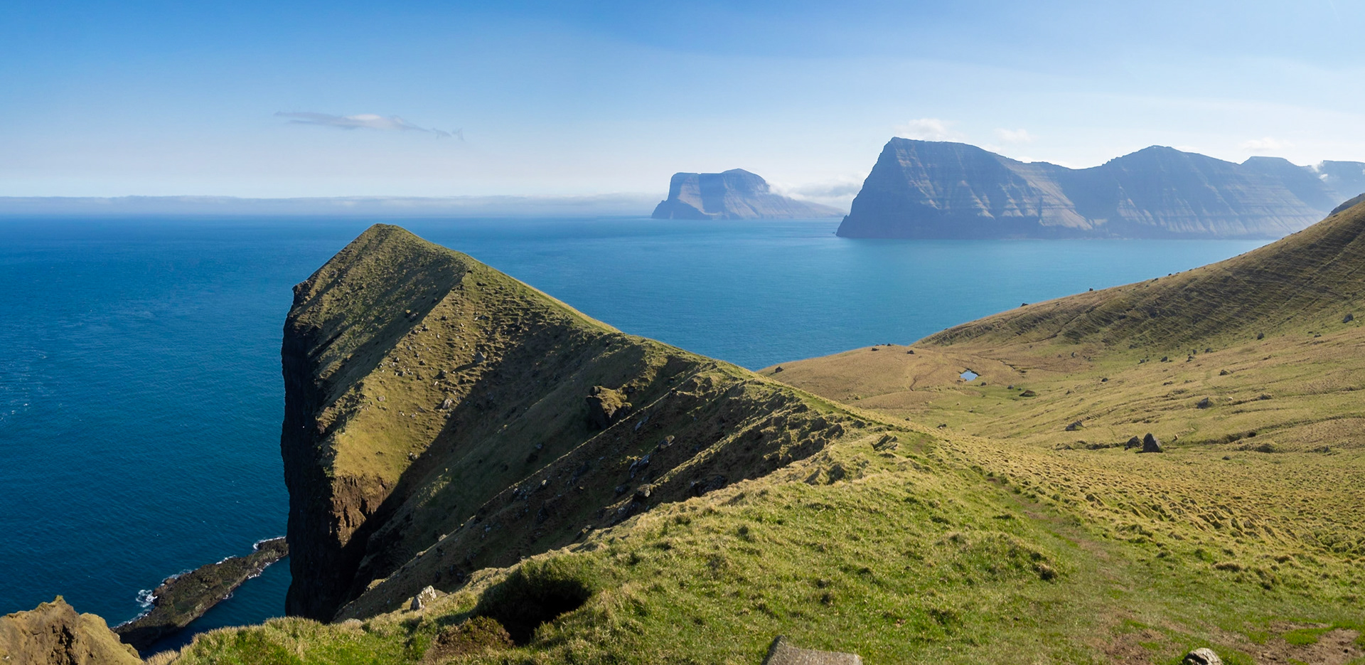 Kallur lighthouse hiking path by the cliffs of north Kalsoy, with Kunoy and Vidoy islands at sight