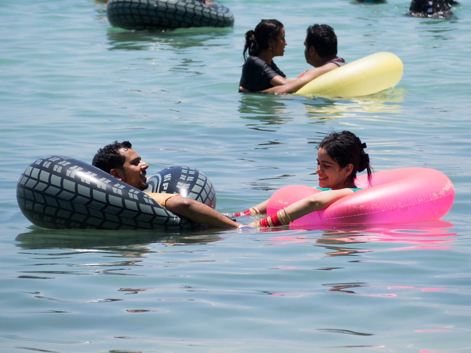 Indian couple in pool floats in the sea