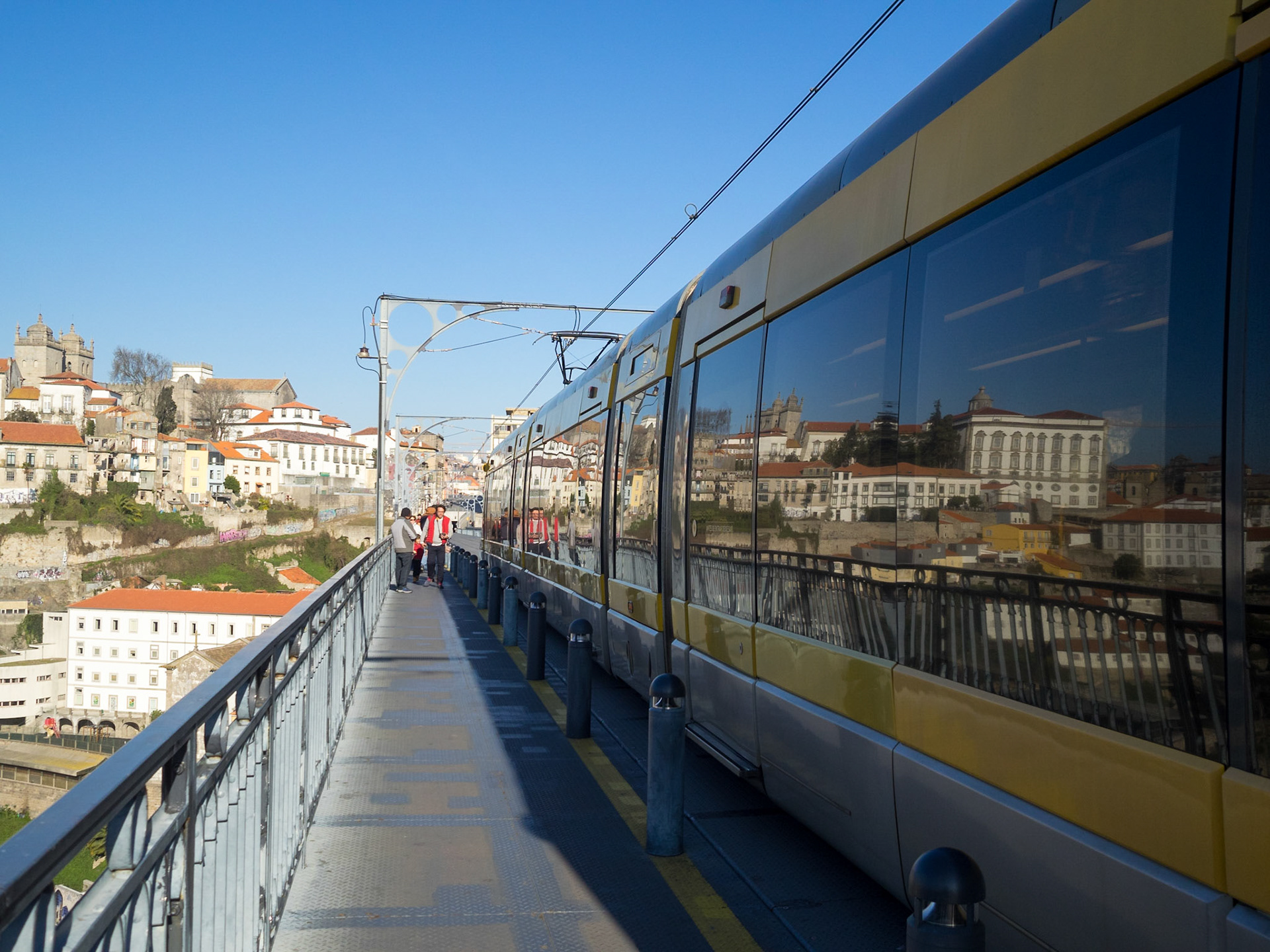 Oporto city reflected in the train crossing Dom Luis Bridge