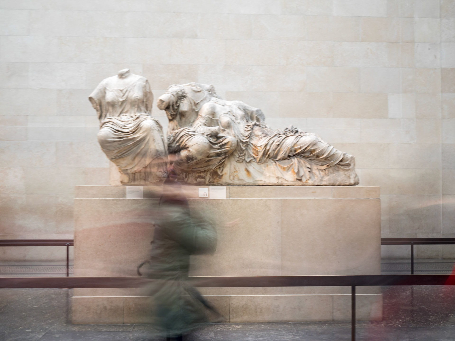 Visitor blurred movement by a Greek statue at the  British Museum