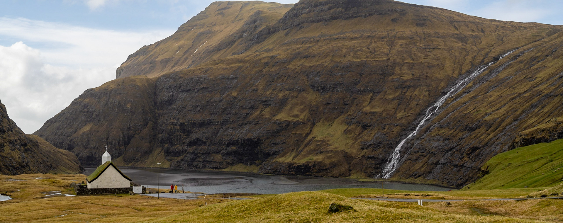 Saksun turf roofed church by the black sand tidal lagoon below the mountains