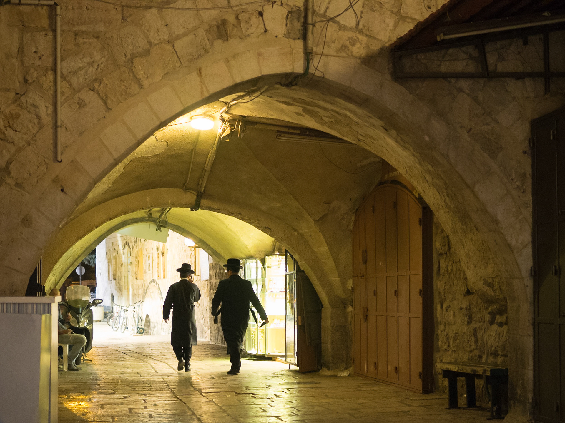 Orthodox Jew men silhouette walking at night in Ole Jerusalem streets