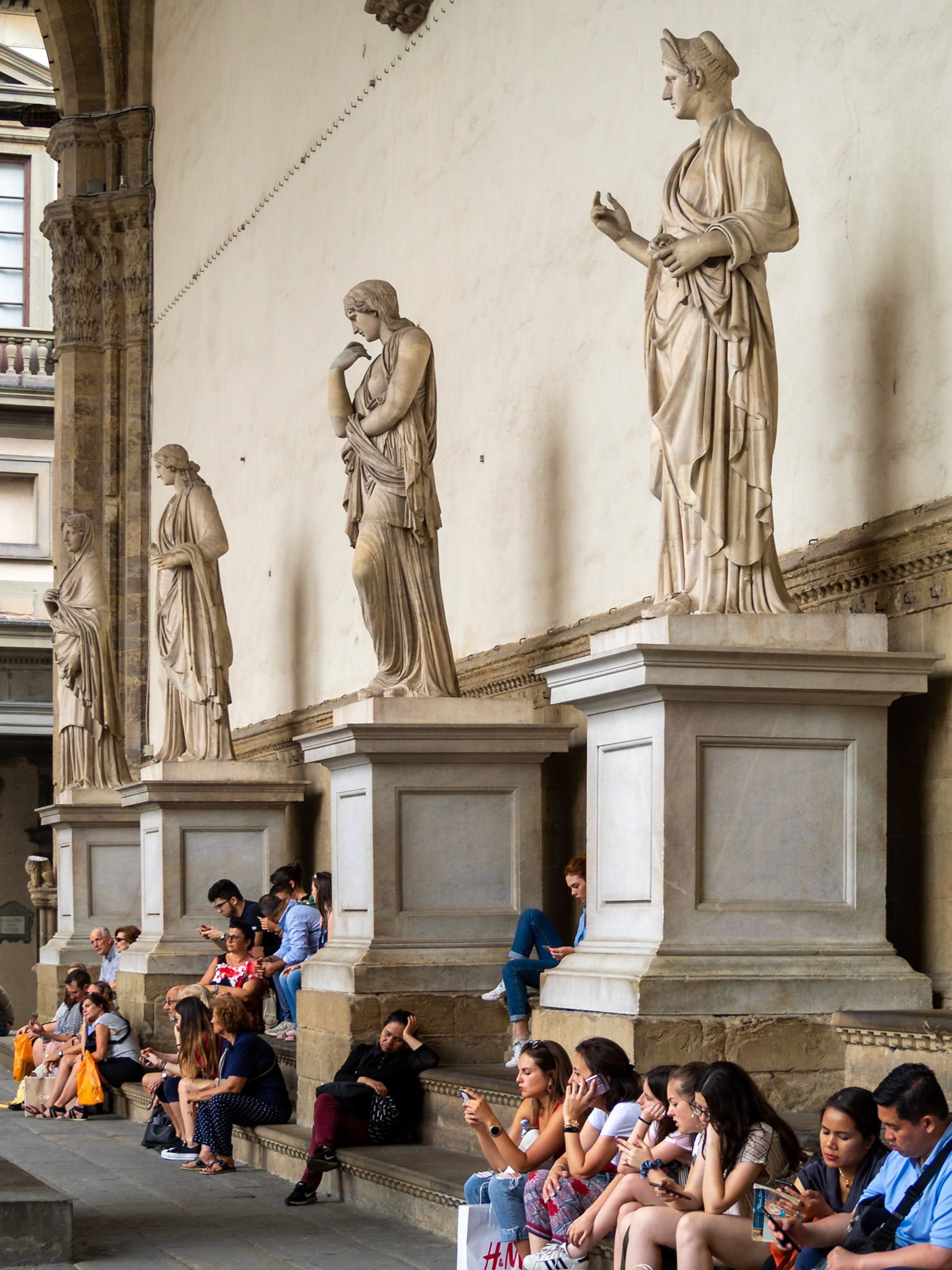 Tourists by the statues in Loggia dei Lanzi, Florence