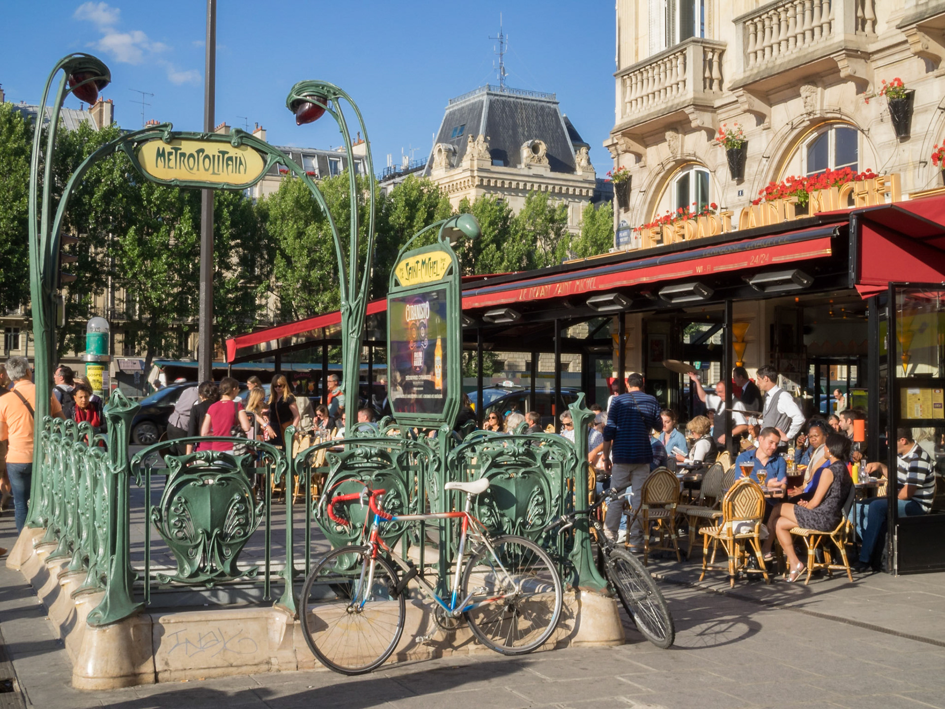 Paris Art Nouveau underground station entrance by a cafe terrace