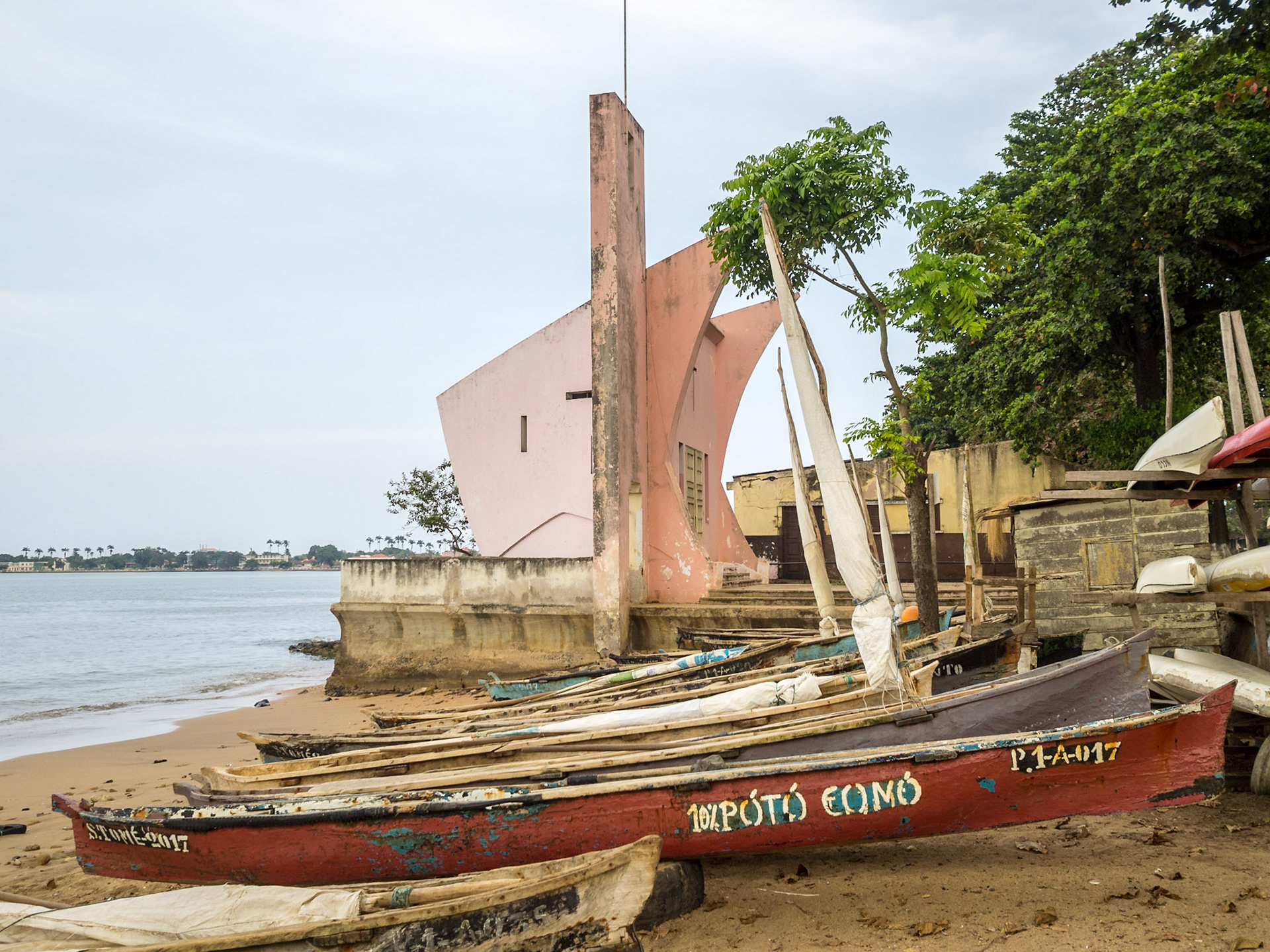 Fishing canoes and modernist architecture chapel by the Sea in São Tomé