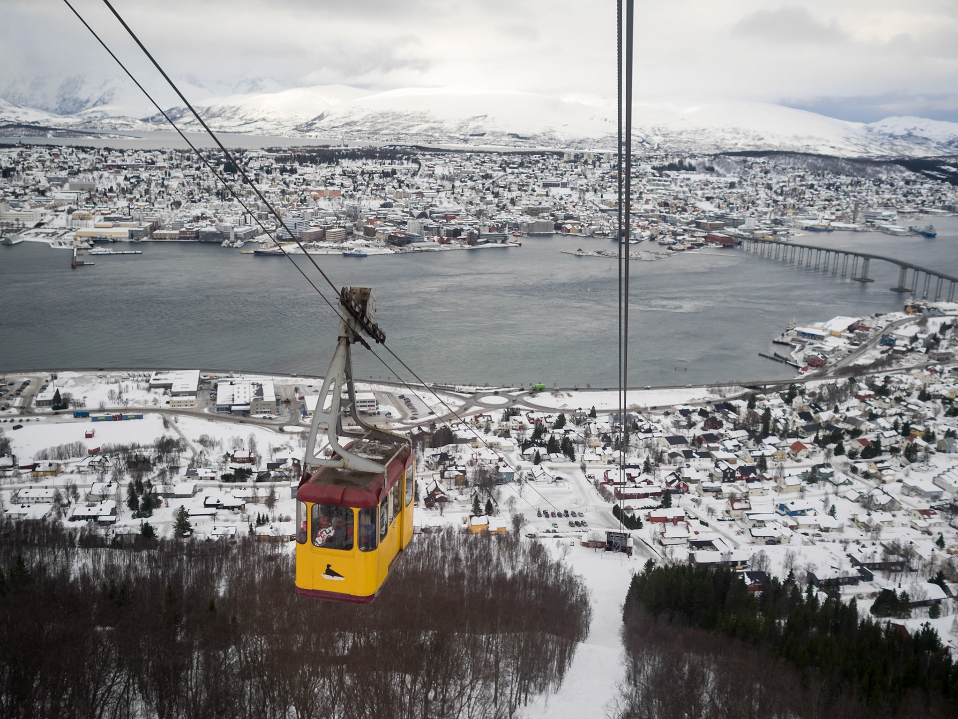 Tromso cable car going up the mountain with winter landscape in background