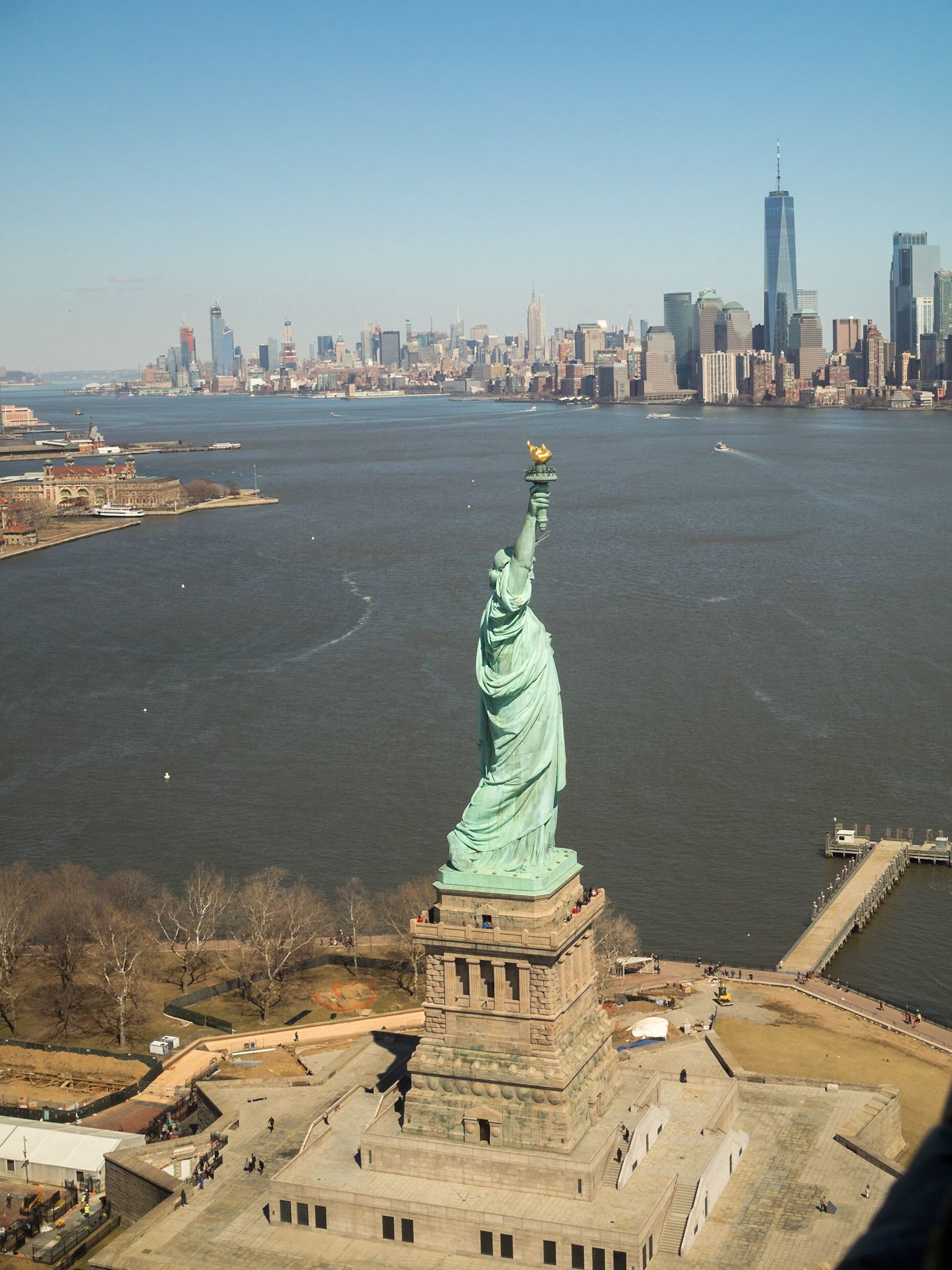 The Statue of Liberty with Manhattan in background seen from an helicopter ride over New York Bay