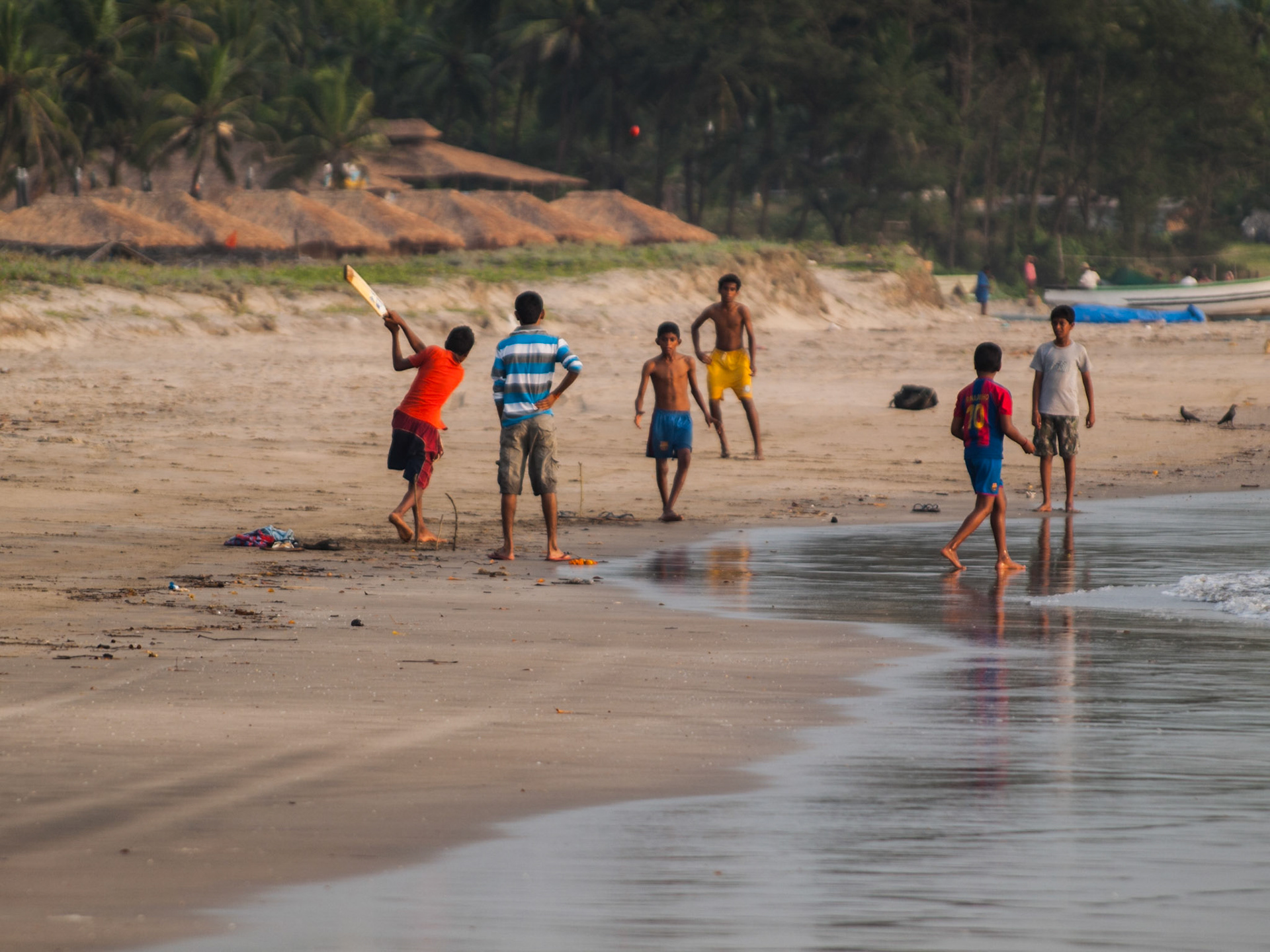 Indian kids playing cricket by the sea in Mandrem beach