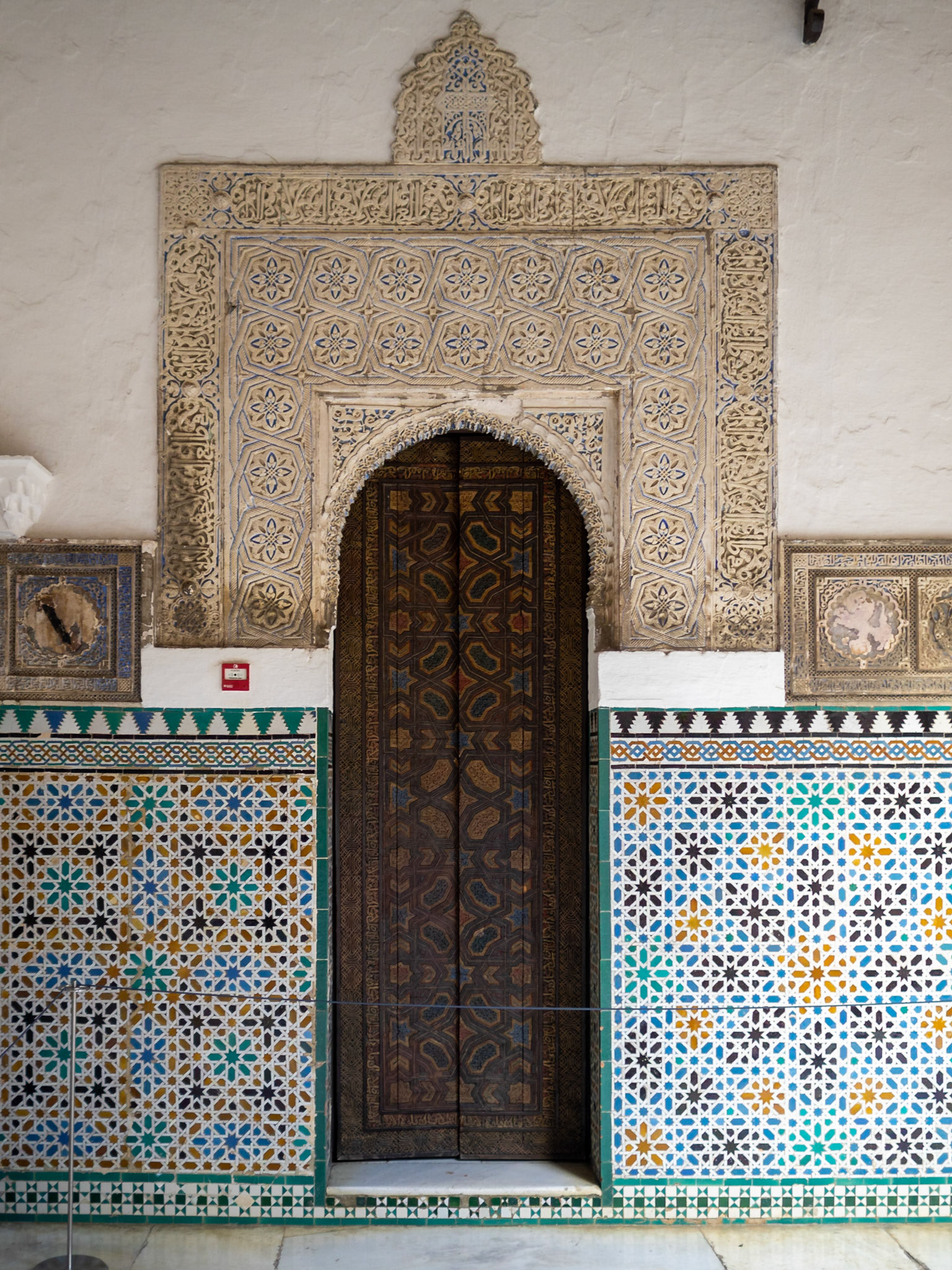 Islamic stucco, geometric patterned tiles and inlaid wooden door, Alcazar of Seville