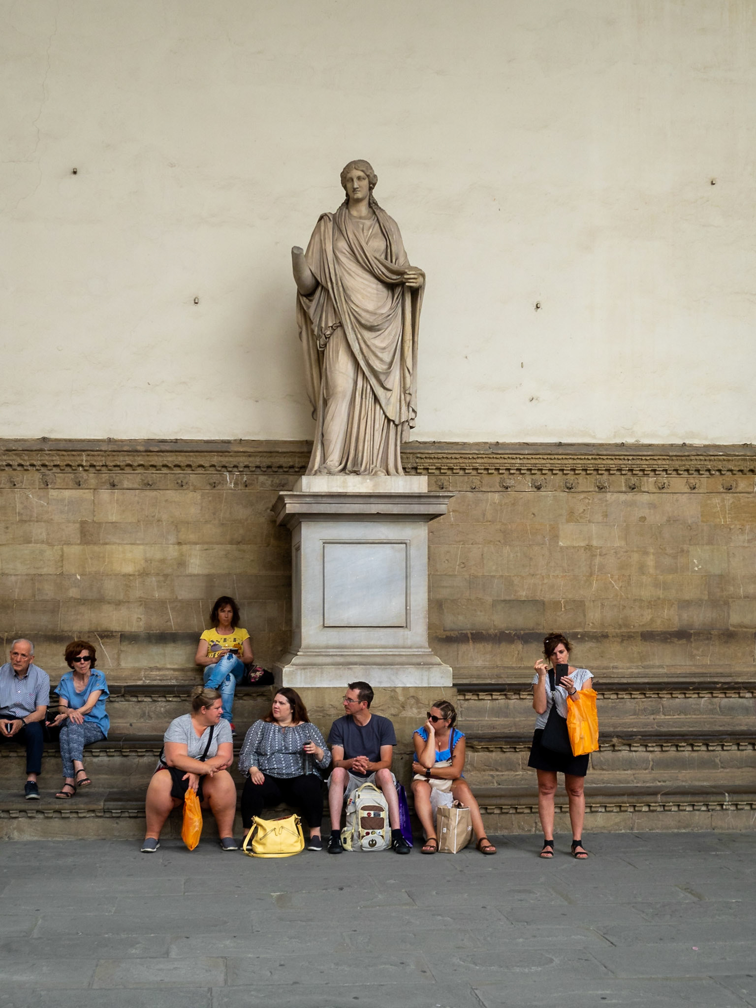 Tourists by a statue in Loggia dei Lanzi, Florence