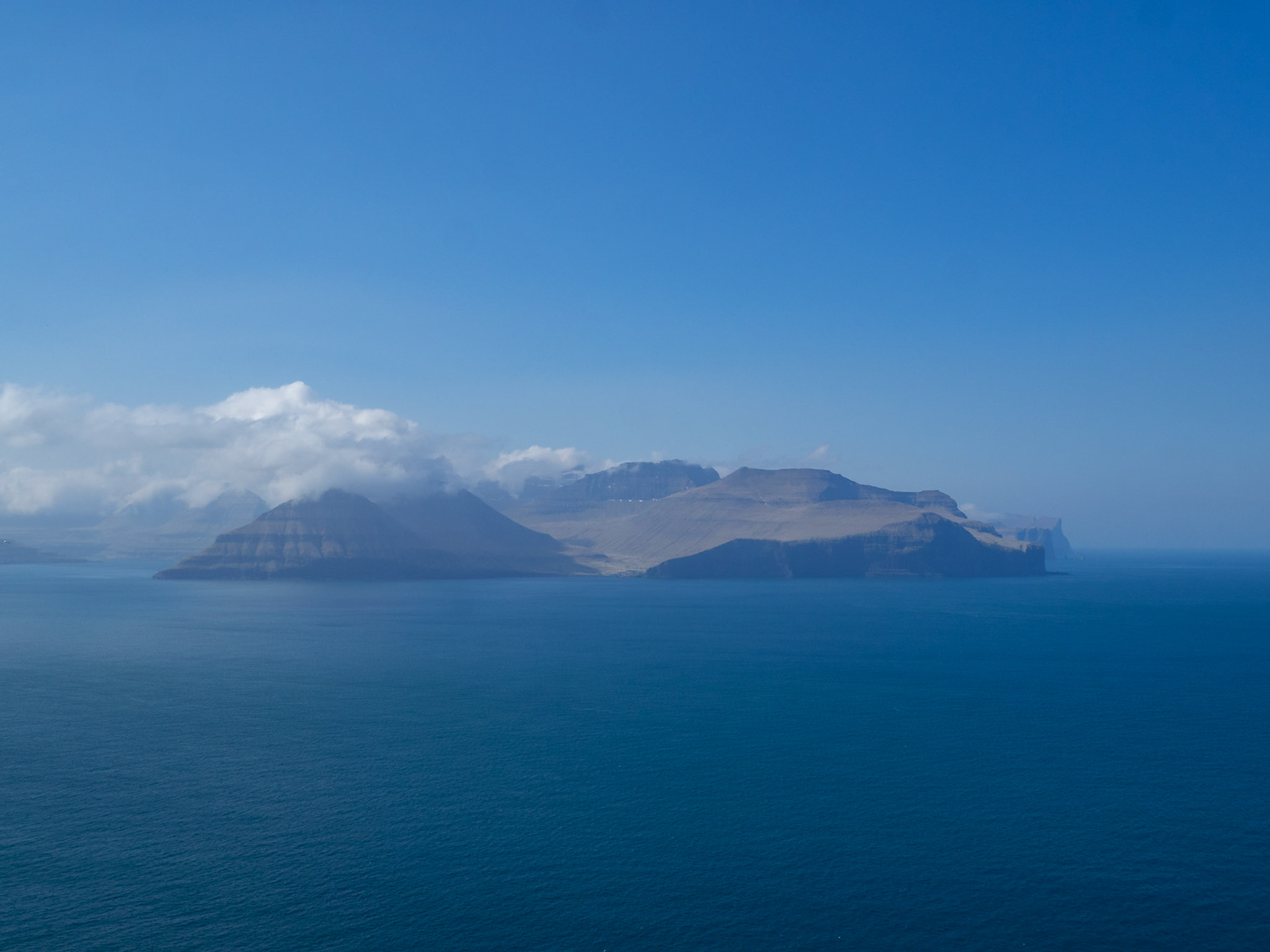 Eysturoy island and Gjogv hamlet in the horizon, seen from Kalsoy Kallur lighthouse hiking path
