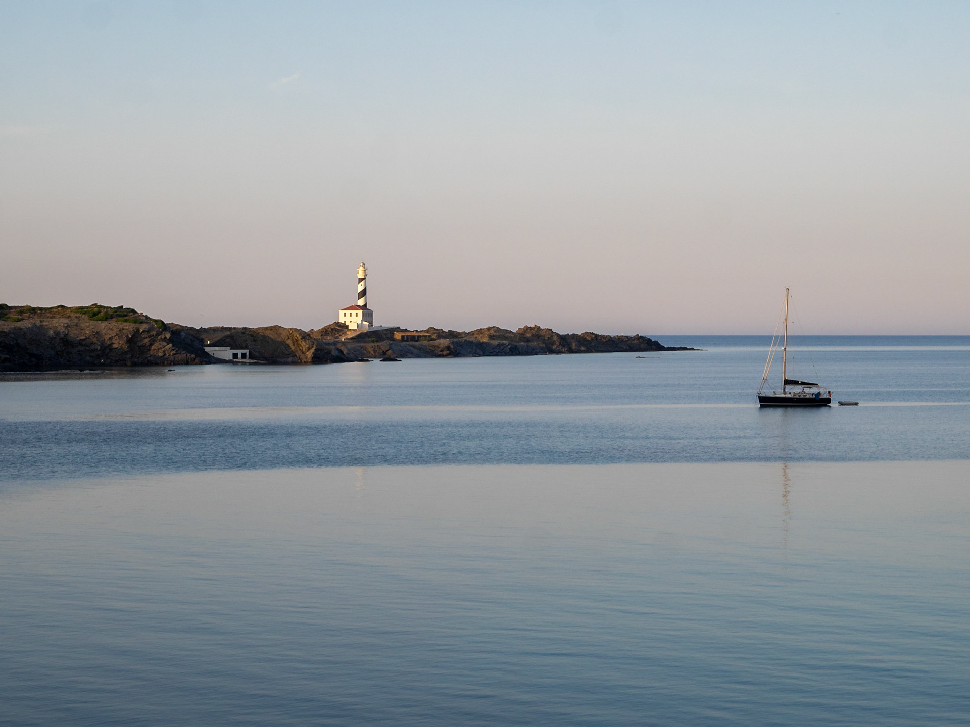 Sailboat in the dusk light by Favaritx Lighthouse, Menorca