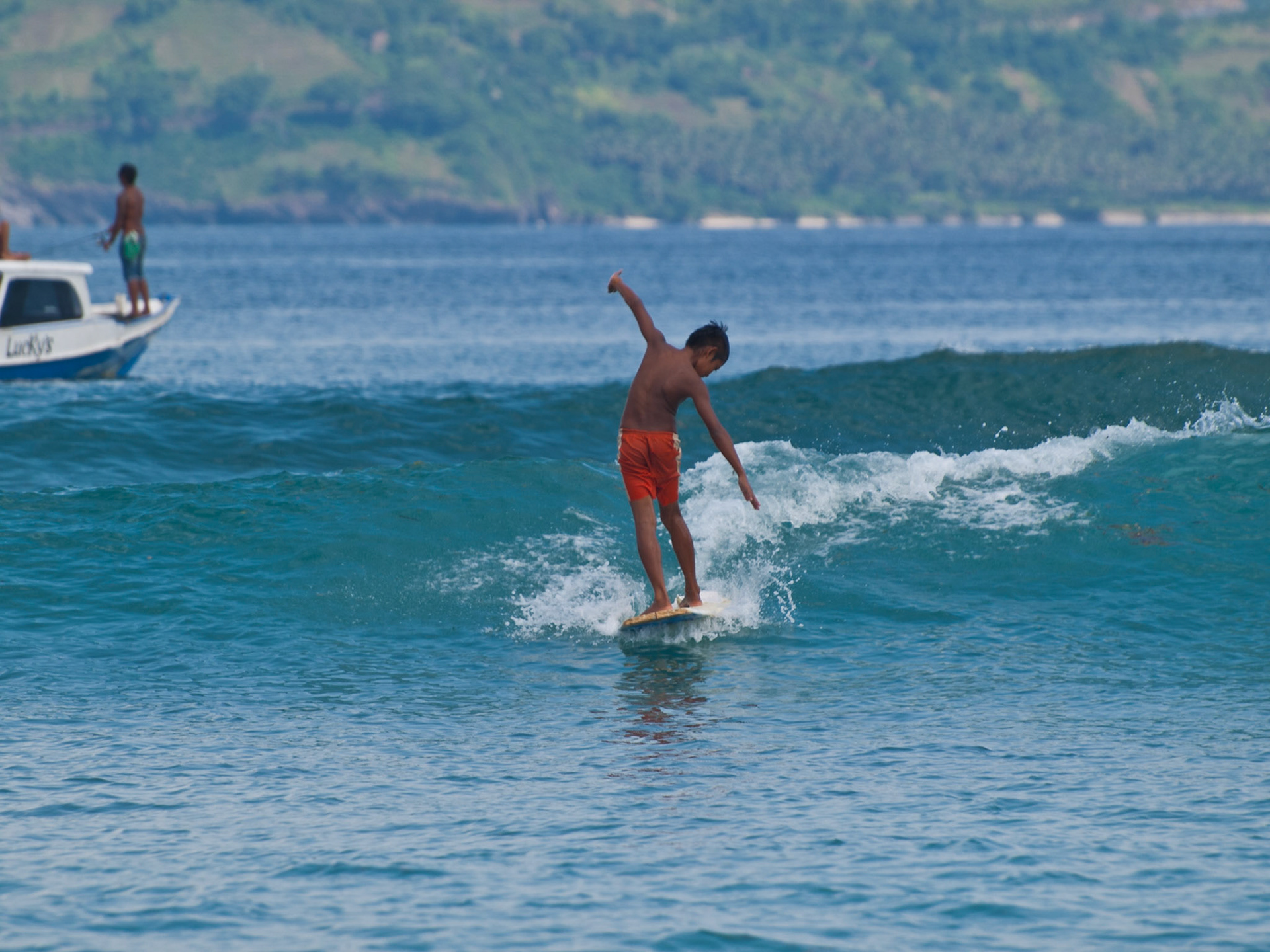 Indonesia n boy surfing the waves between Gili Trawangan and Lombok