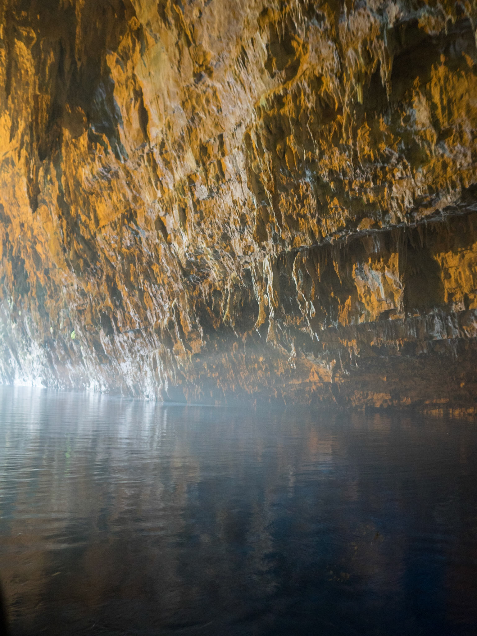 Melissani caves stone walls with the light reflecting in the water