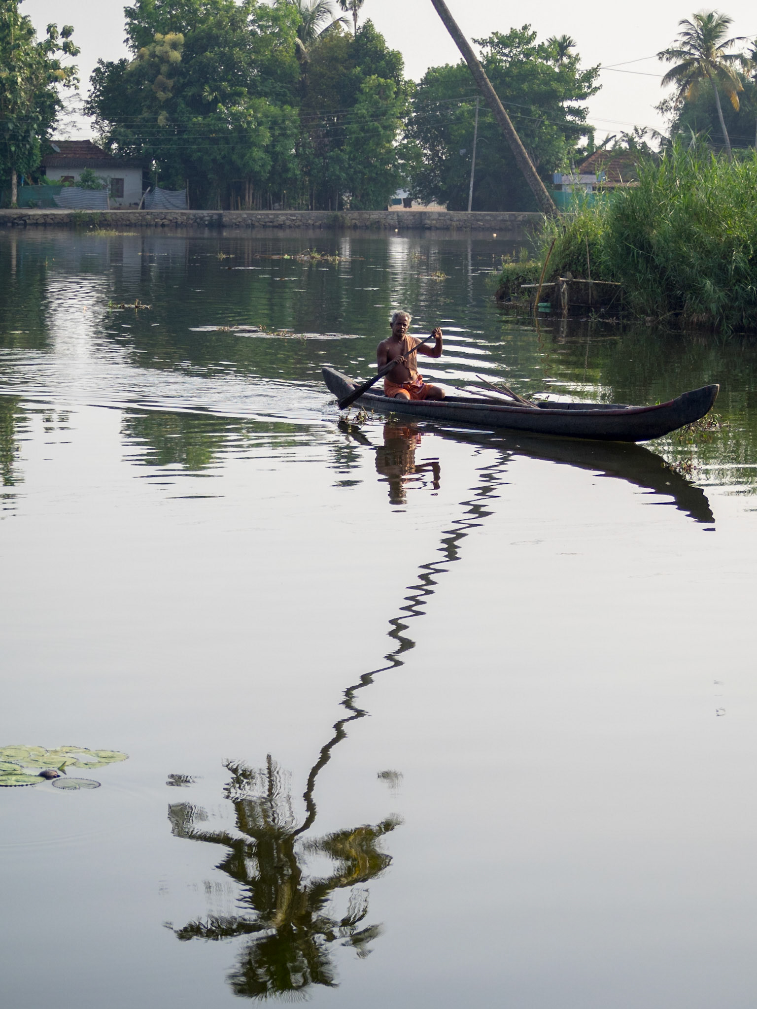 Man in a canoe in Kerala backwaters
