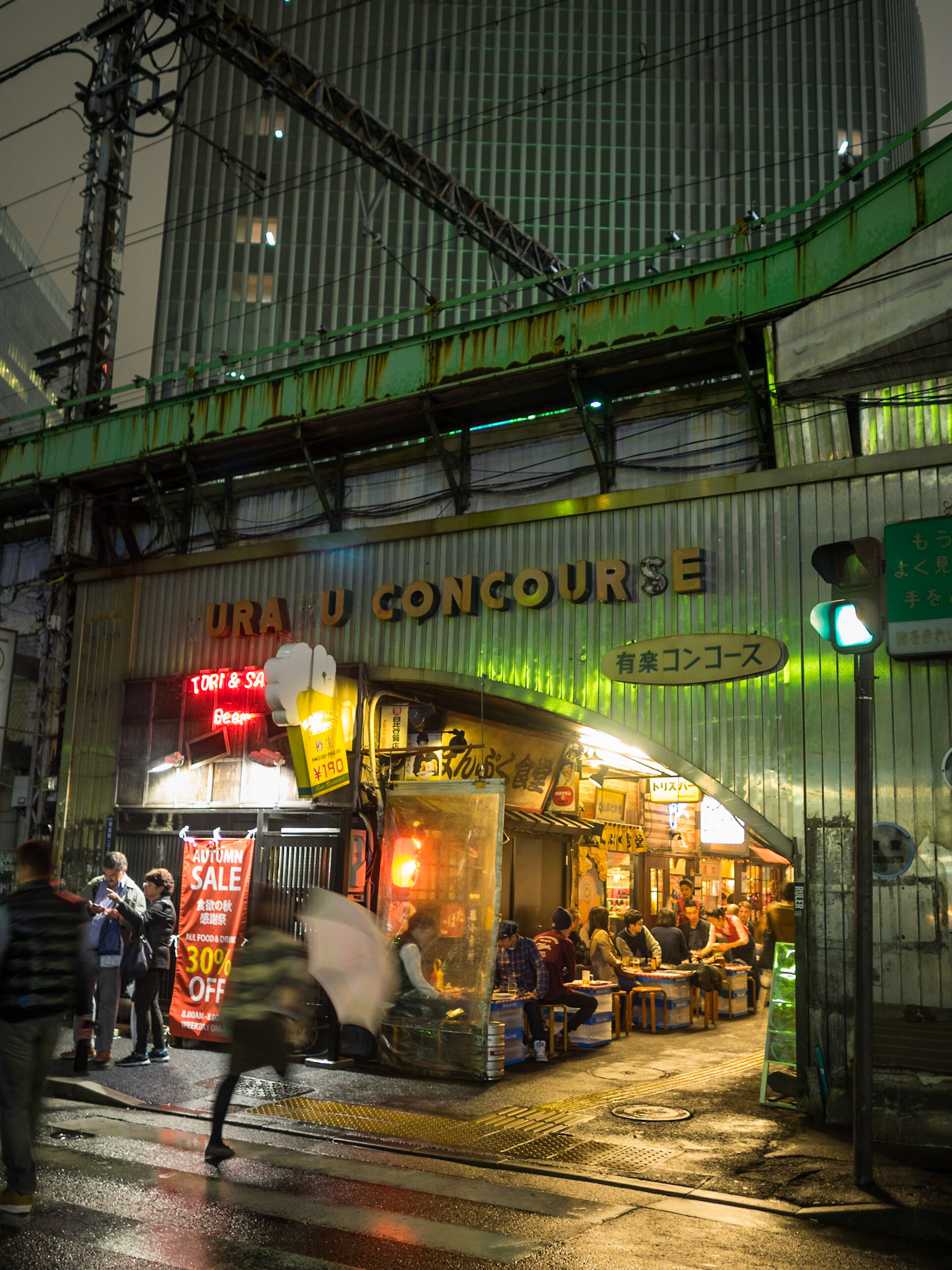 People eating in traditional Tokyo restaurants under the train lines