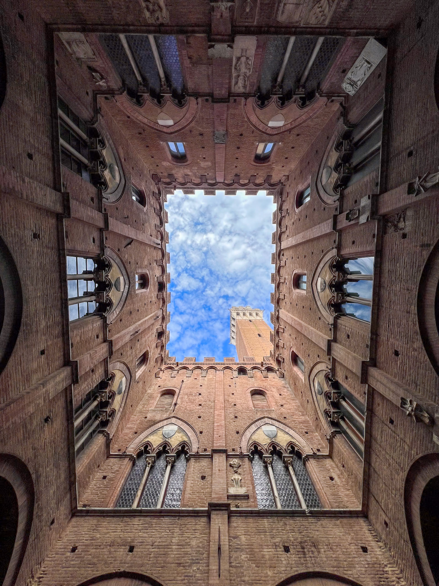 Looking up at Torre del Mangia from the interior of Palazzo Pubblico courtyard, Siena