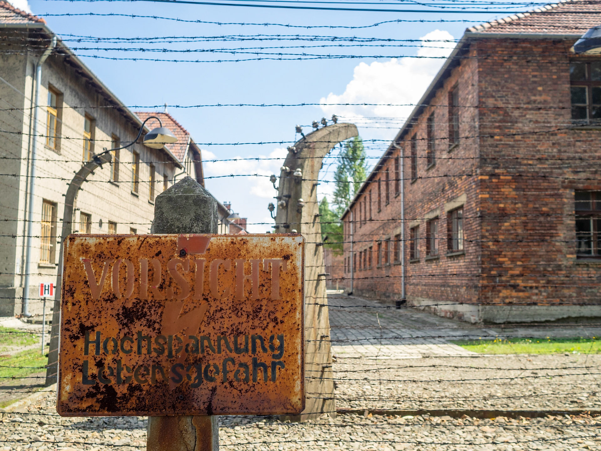 Barbed wire and brick barracks buildings of Auschwitz Concentration Camp
