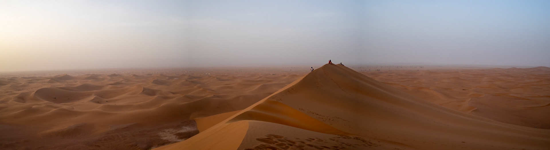 Watching the sunset at the crest of Erg Chegaga sand dune, Morocco