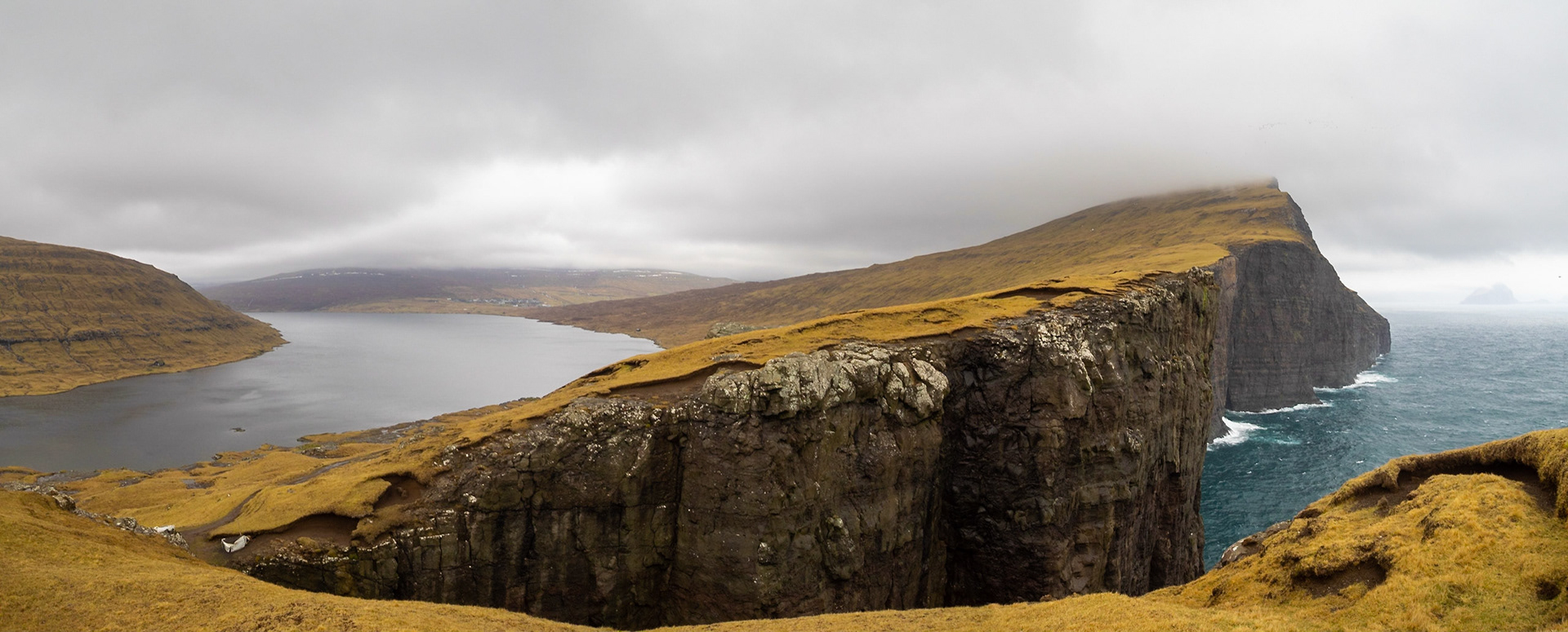 Leitisvatn lake over the ocean cliffs seen from Trælanípa