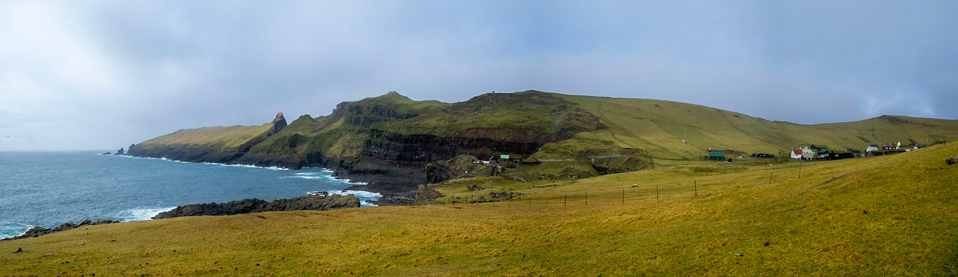 Mykines island panorama with the lighthouse promontory and hamlet houses