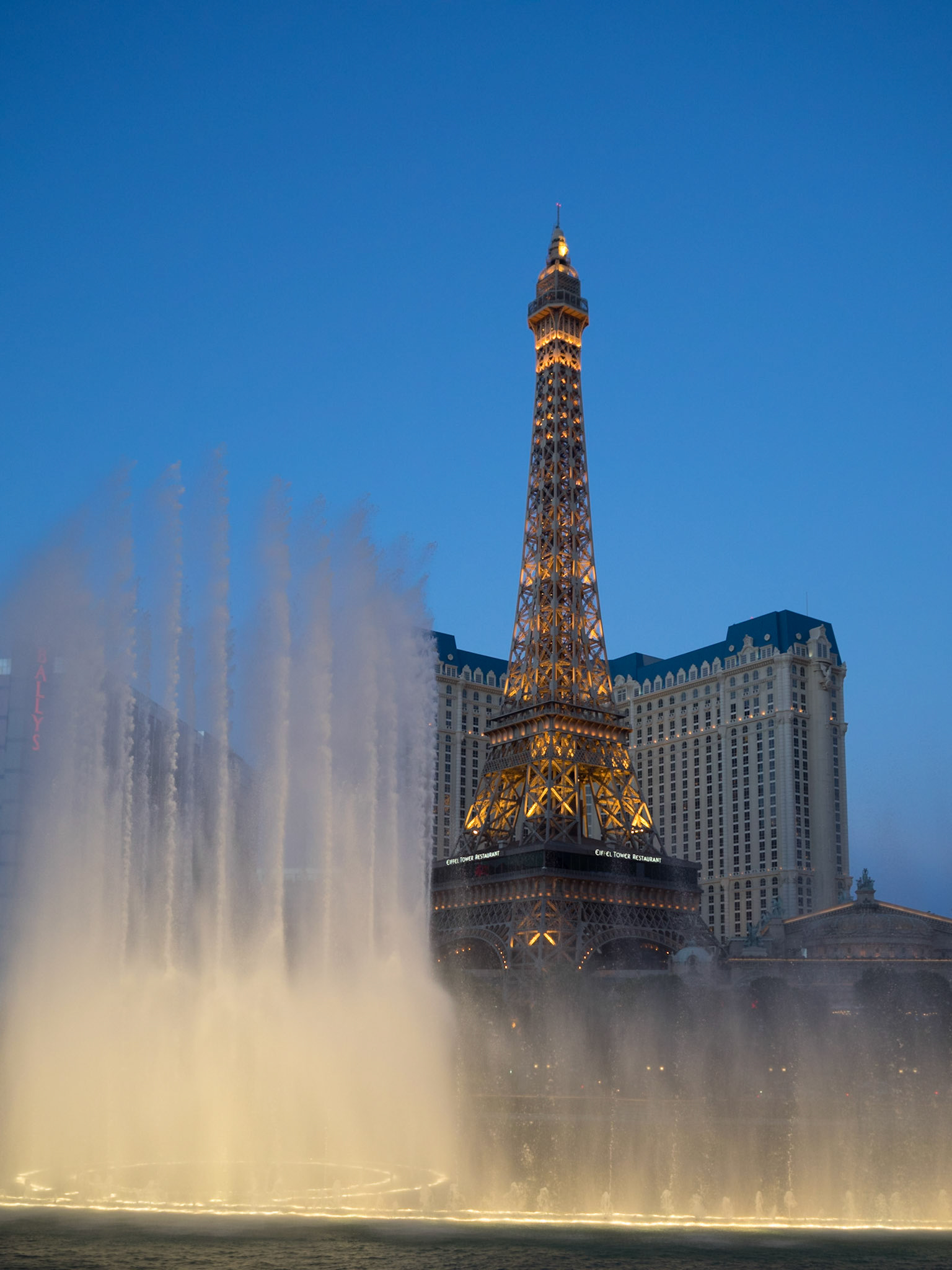 Bellagio Hotel and Casino fountains light show with Paris Las Vegas Eiffel Tower in background