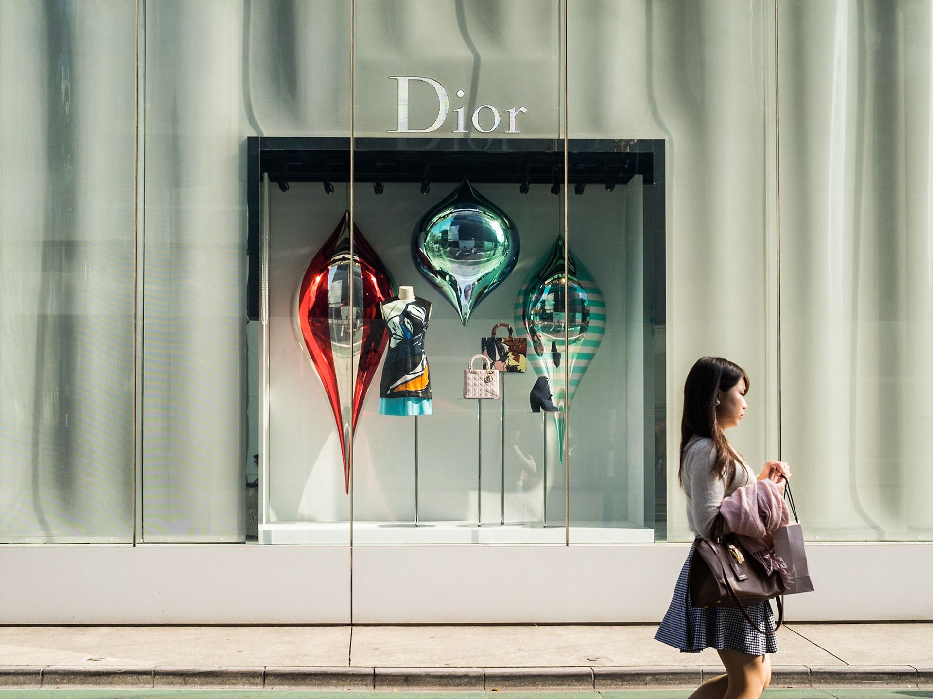 Woman passing by Dior shopwindow in Omotesando street