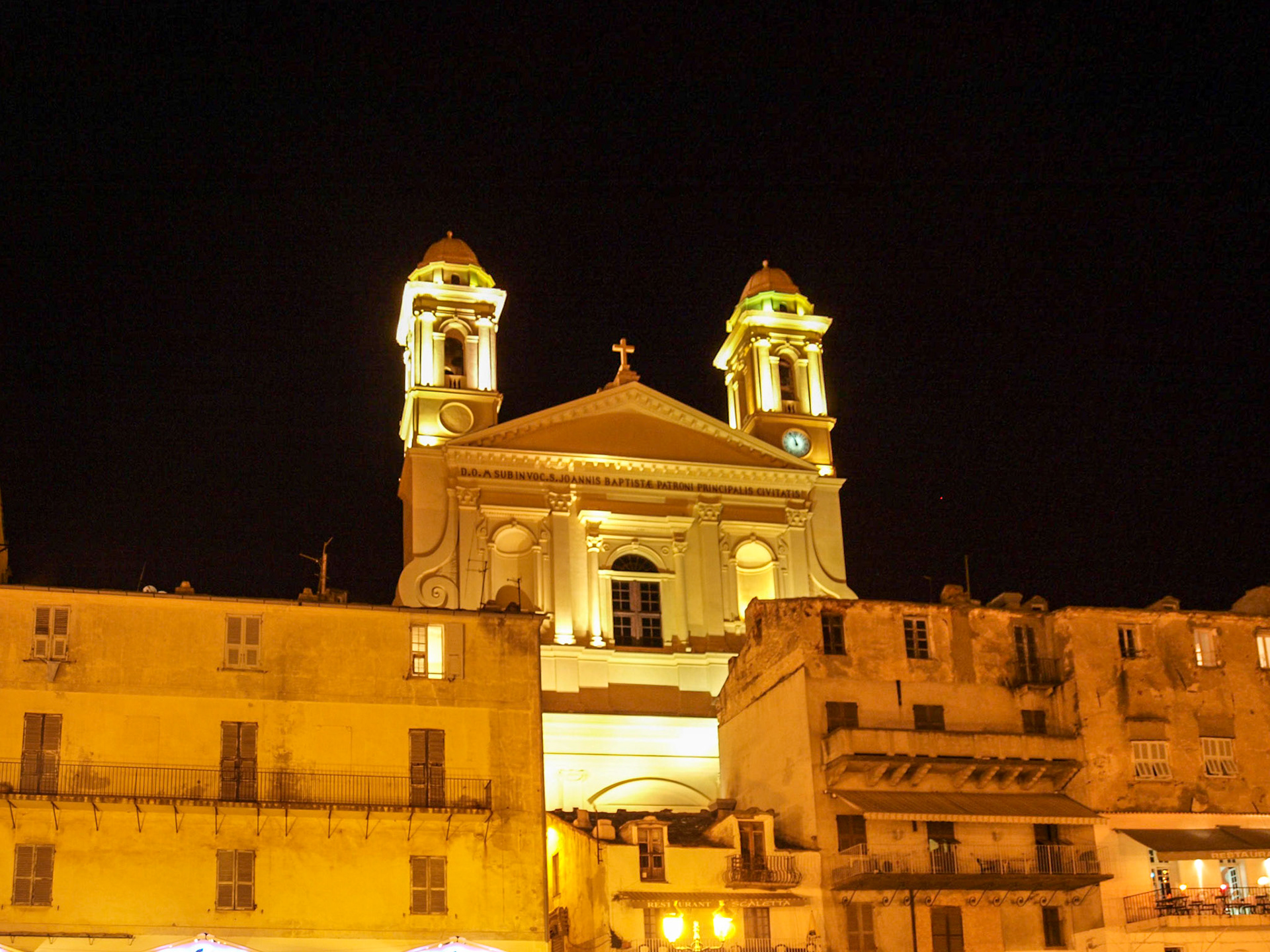 Bastia St John Baptist towers over the city houses at night