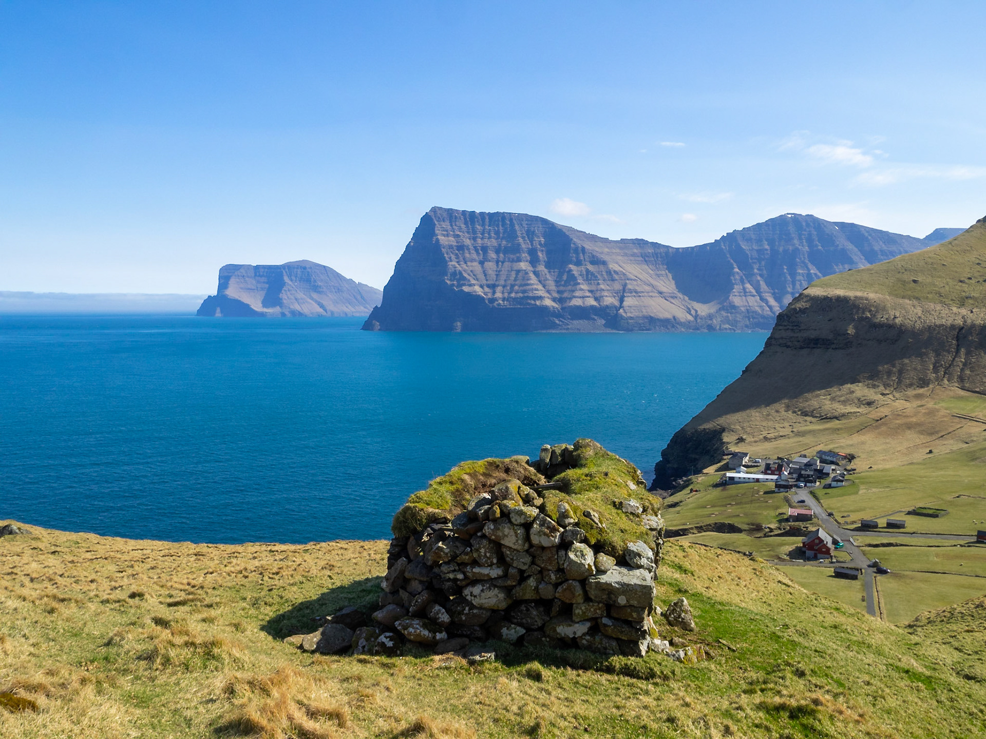 An old stone house with turf roof, in north Kalsoy, with Kalsoy and Vidoy islands in background