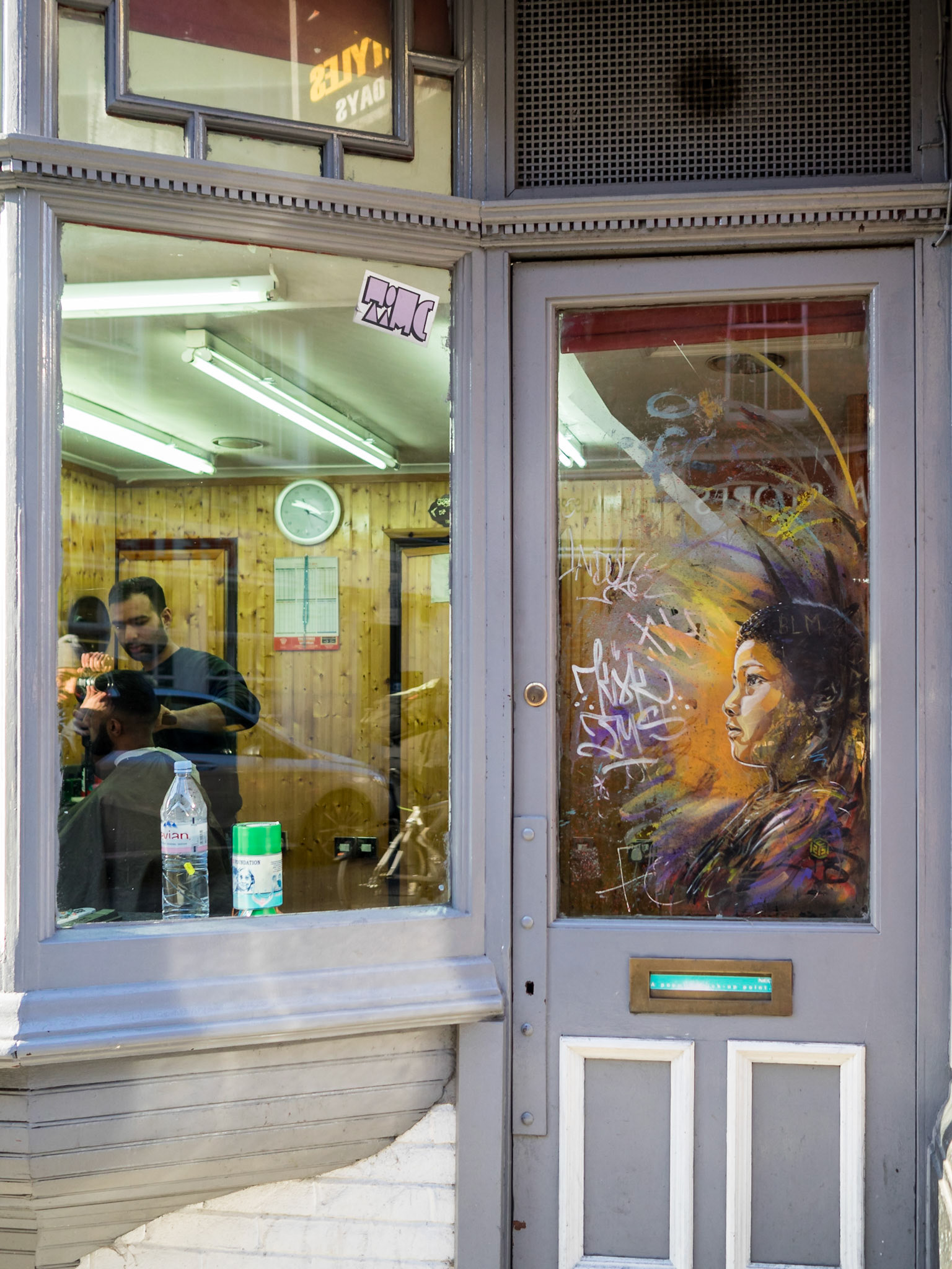 Graffiti on the door of a barbershop of Brick Lane, London