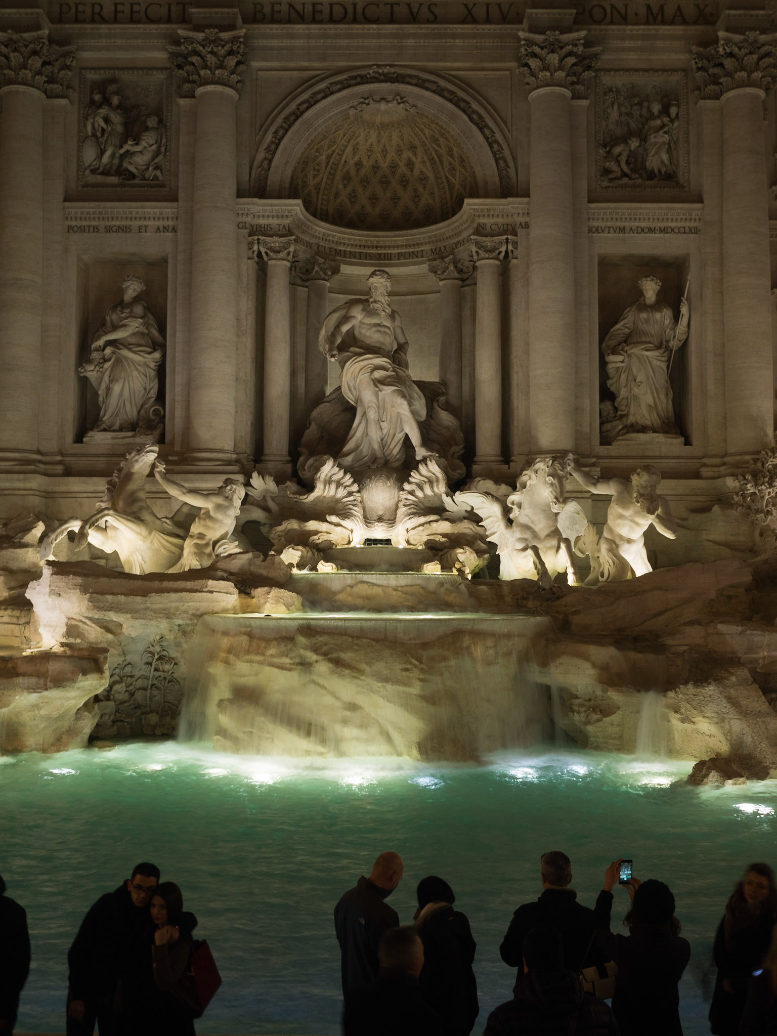 Tourists taking pictures of Fontana di Trevi at night