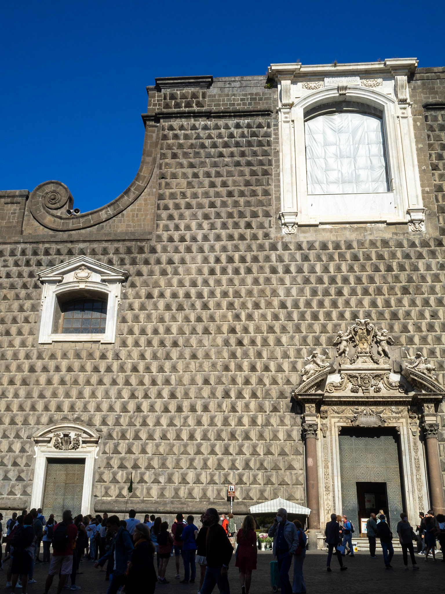 Tourists silhoettes by the Gesú Nuovo Church facade, Naples