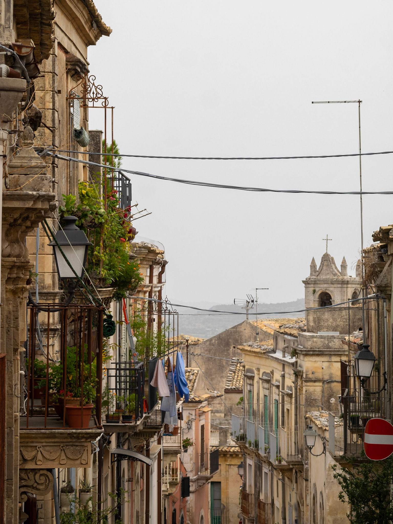 Balconies framing a street of Palazzolo Acreide
