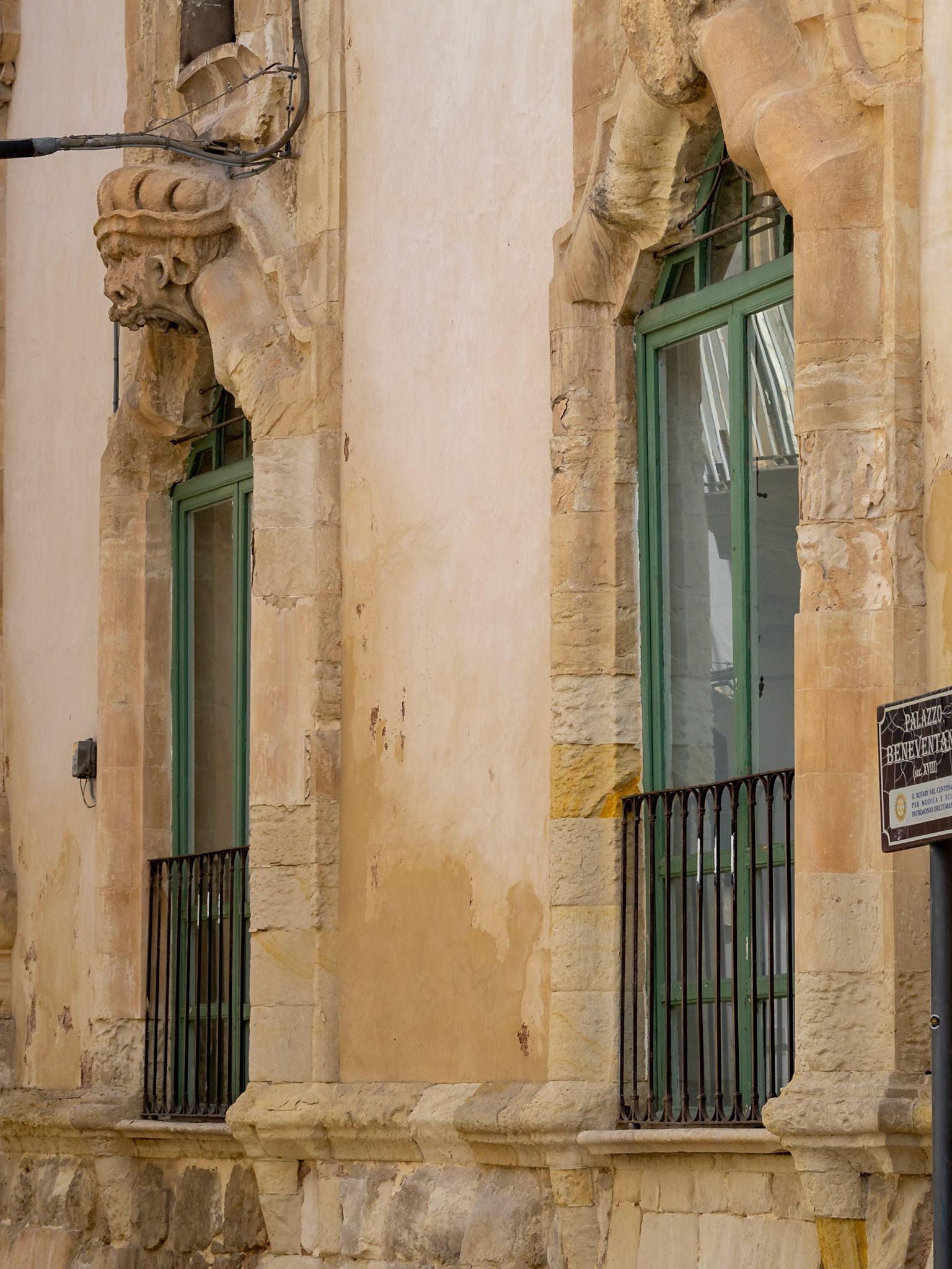 Door decorations with grotesque faces of the Baroque Palazzo Beneventano, Scicli