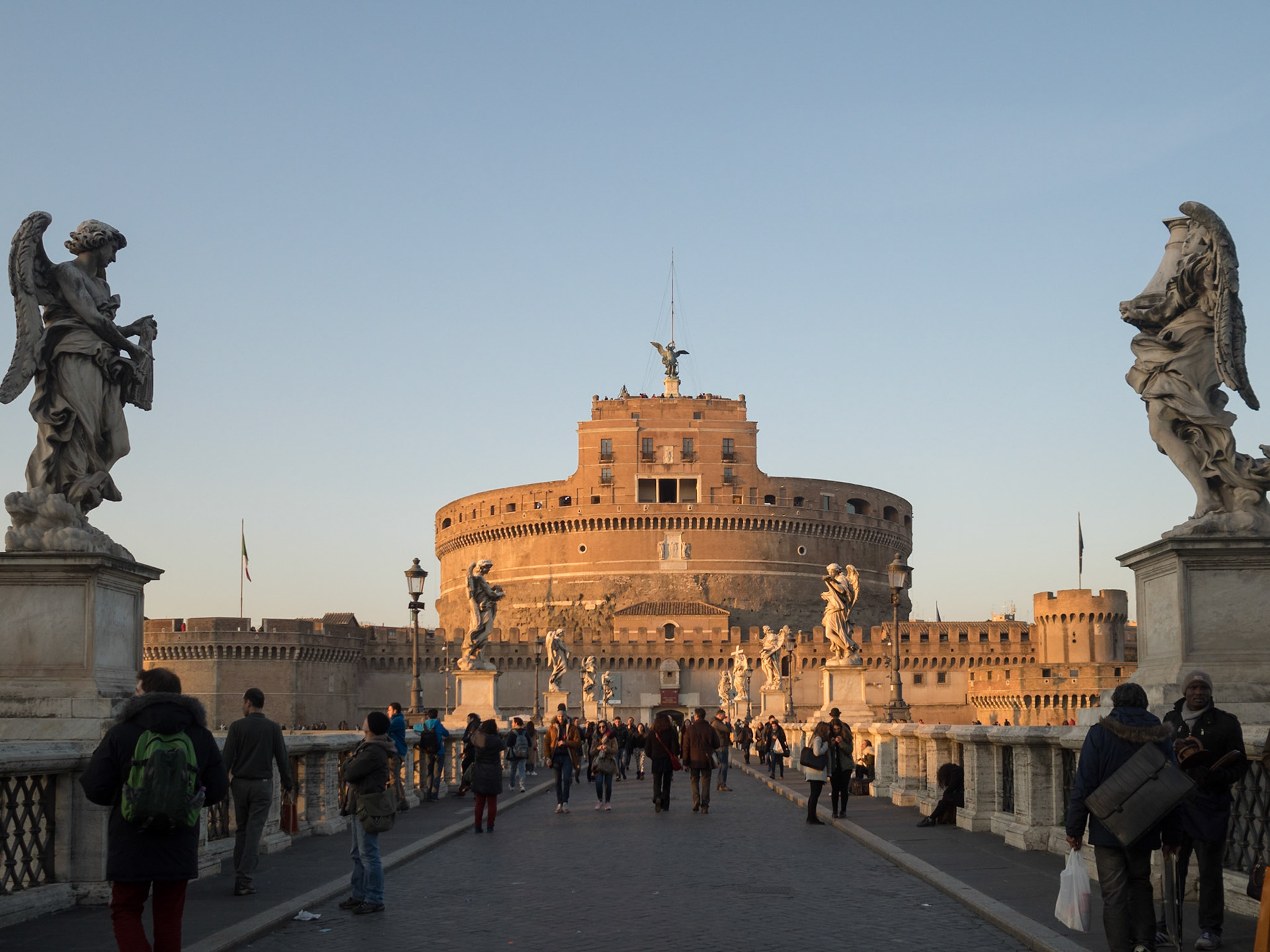 Tourists on Sant'Angelo bridge with Castle Sant'Angelo in background