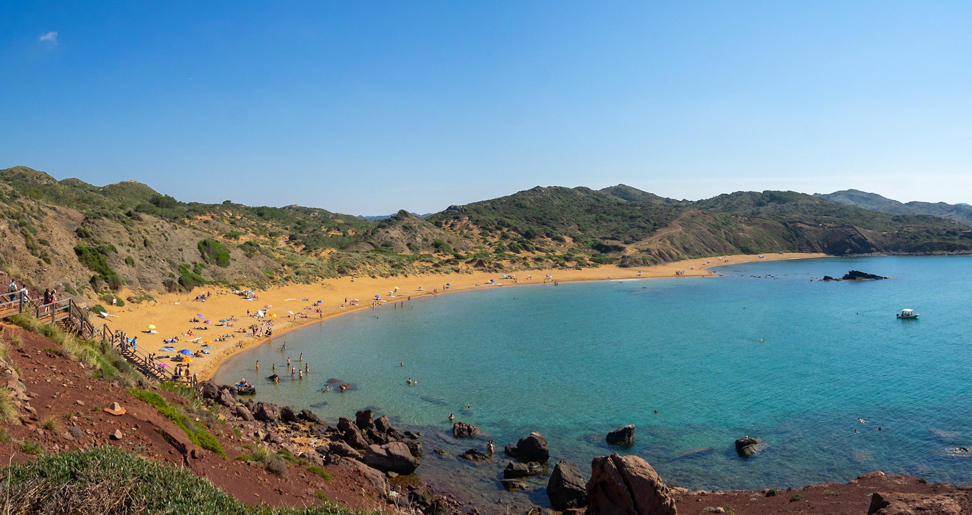 Panorama of the red sand beach Platja de Cavalleria, Menorca