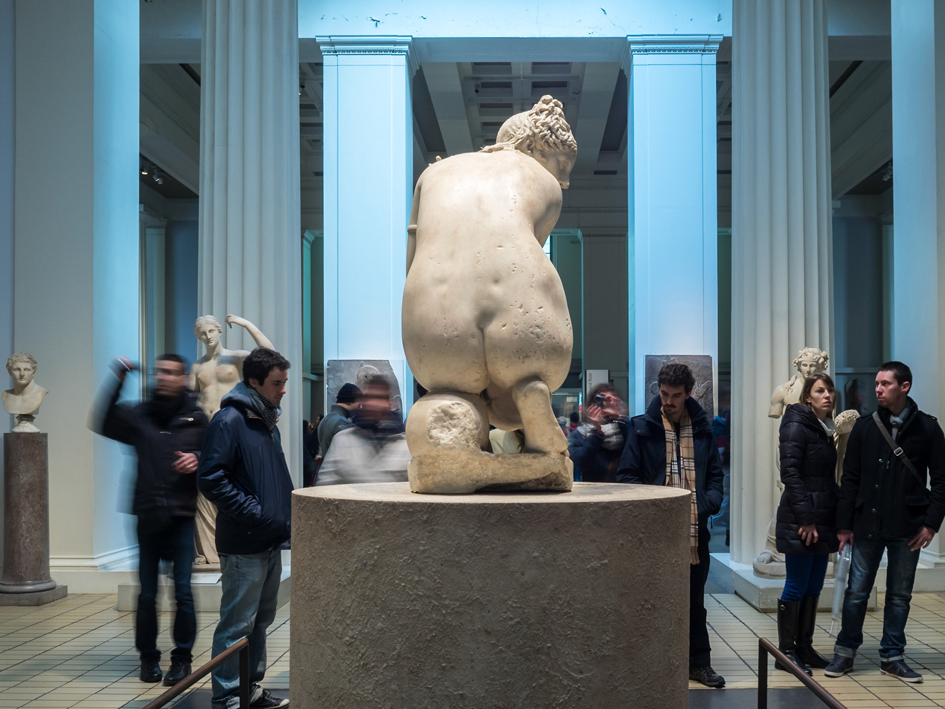 Visitors by woman statue in the British Museum