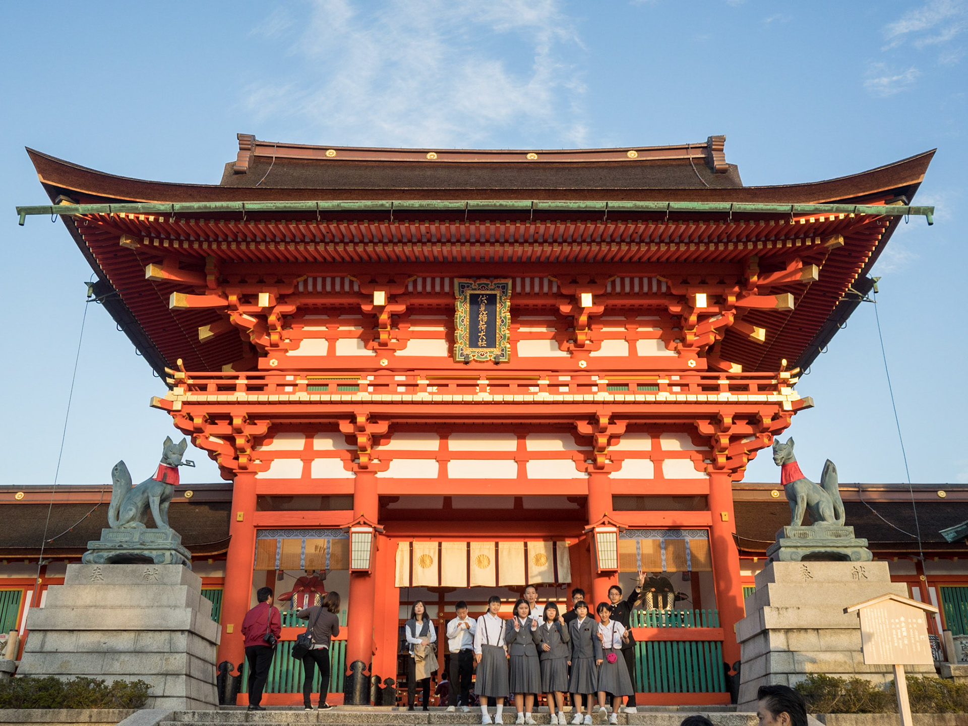 Japanese students group taking a picture in front of Fushimi-Inari-Taisha temple main building