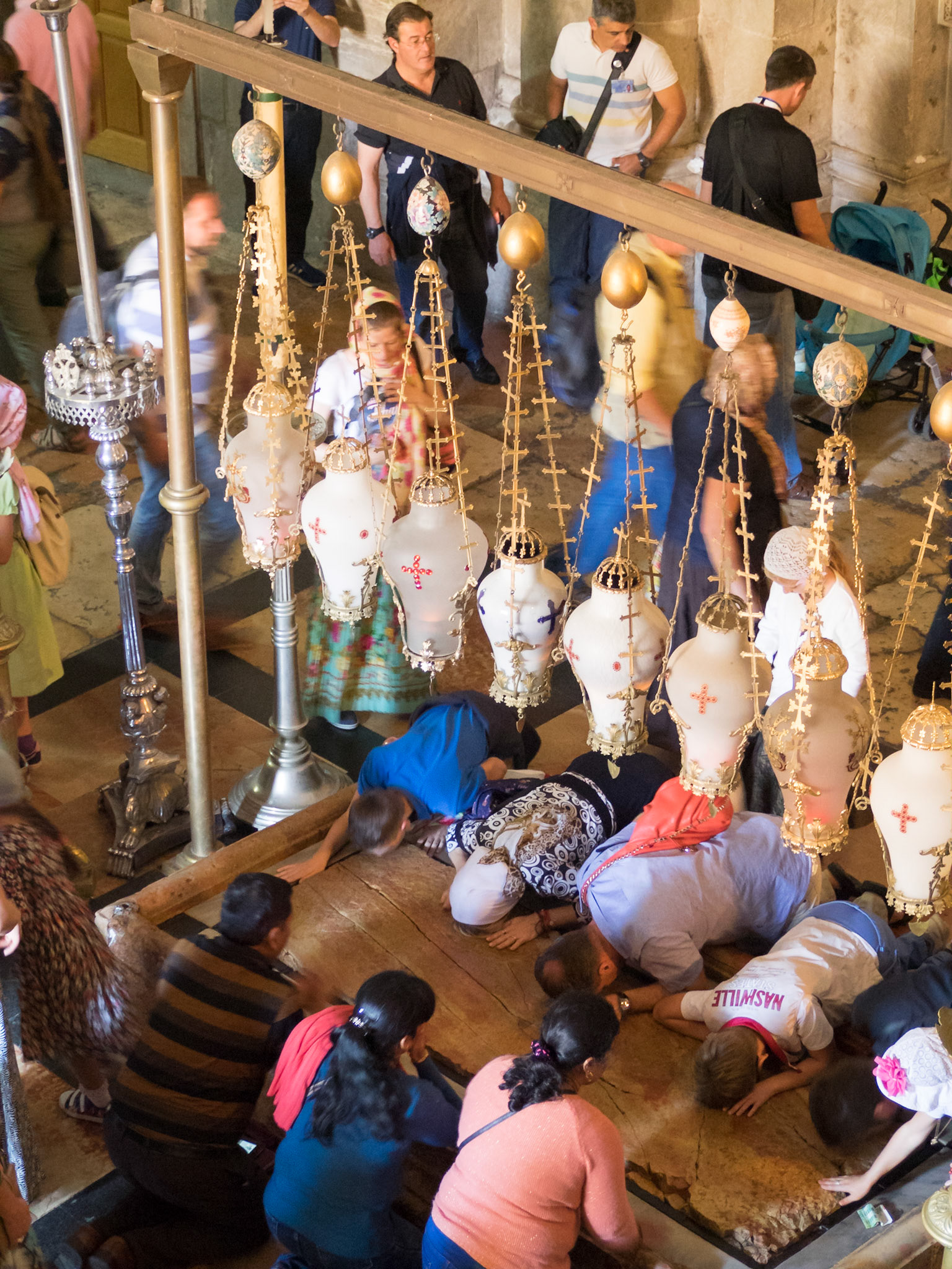 People praying and kneeling by the Stone of Unction, Church of the Holy Sepulcher