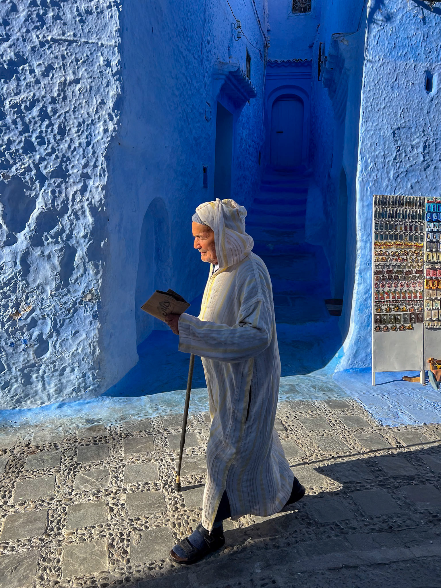 An old man walking the indigo Chefchaouen streets, Morocco