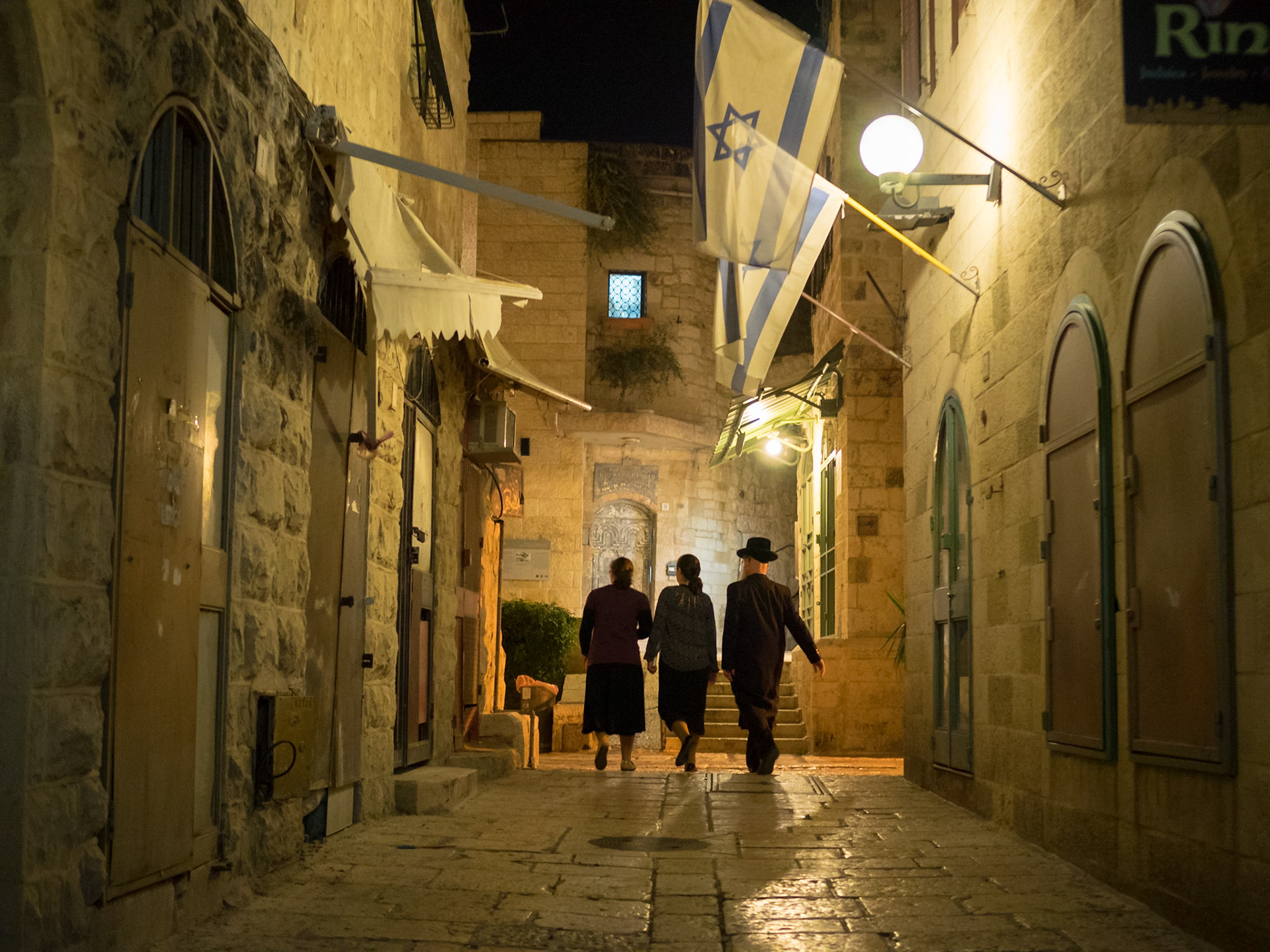 Jewish family walking at night in the streets of Old Jerusalem Jewish Quarter