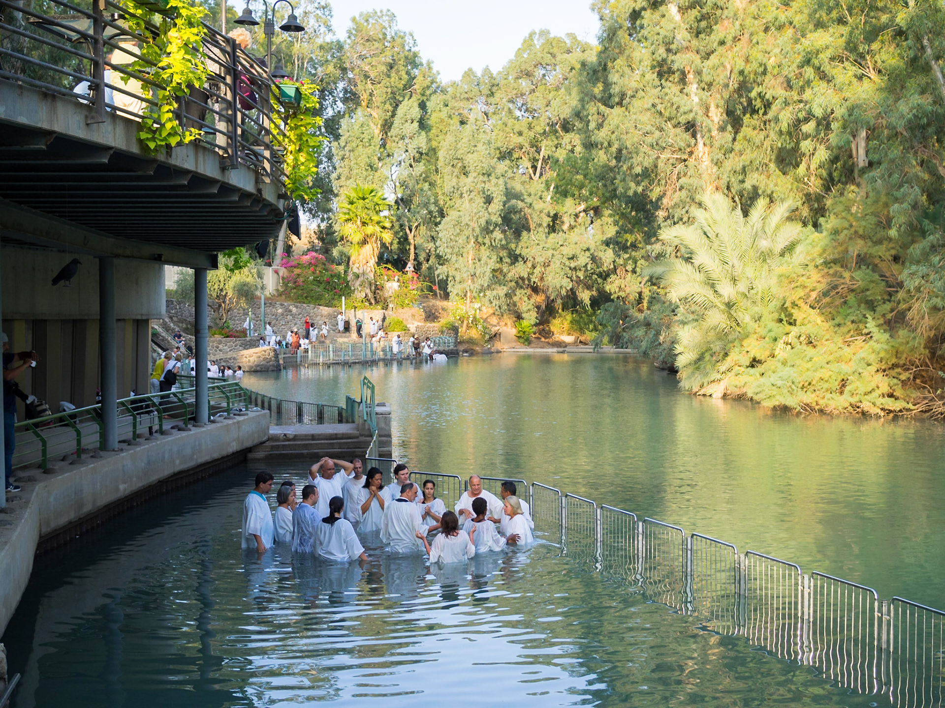 Christian group praying inside the water at the Yardenit baptismal site in Jordan river