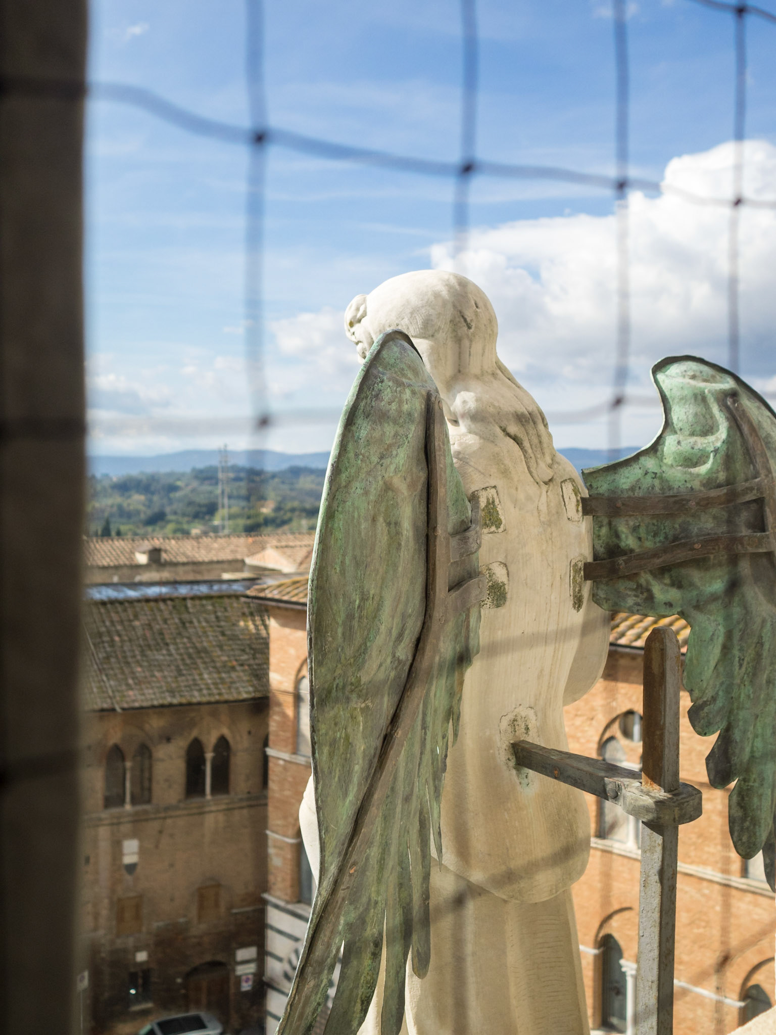 Behind an angel statue of Siena Duomo facade