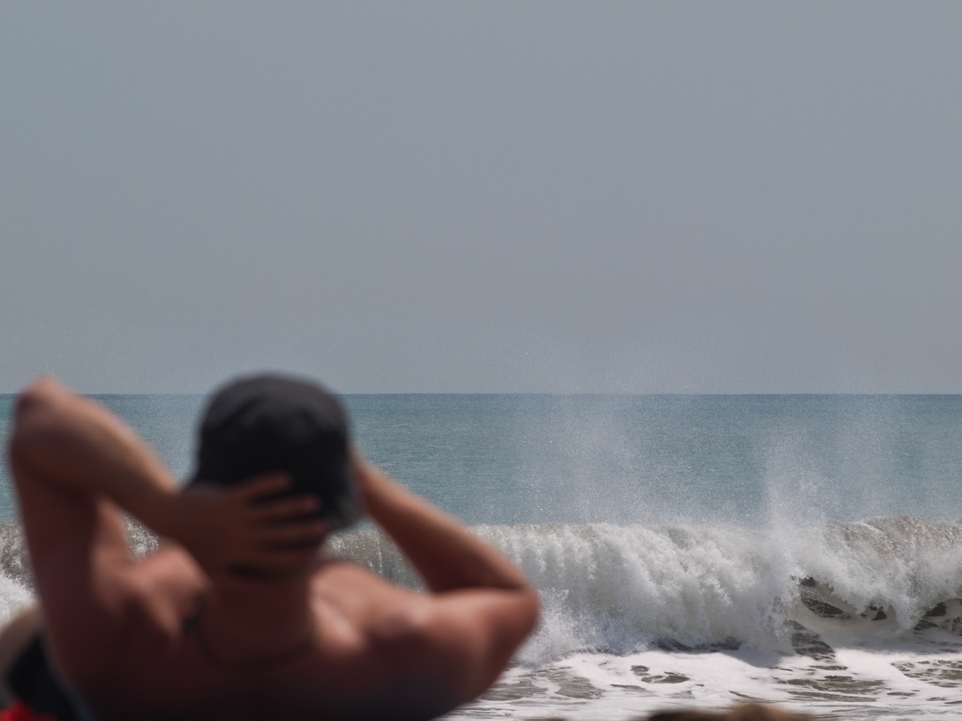 Tourist in the sun in Kuta beach with the sea in background